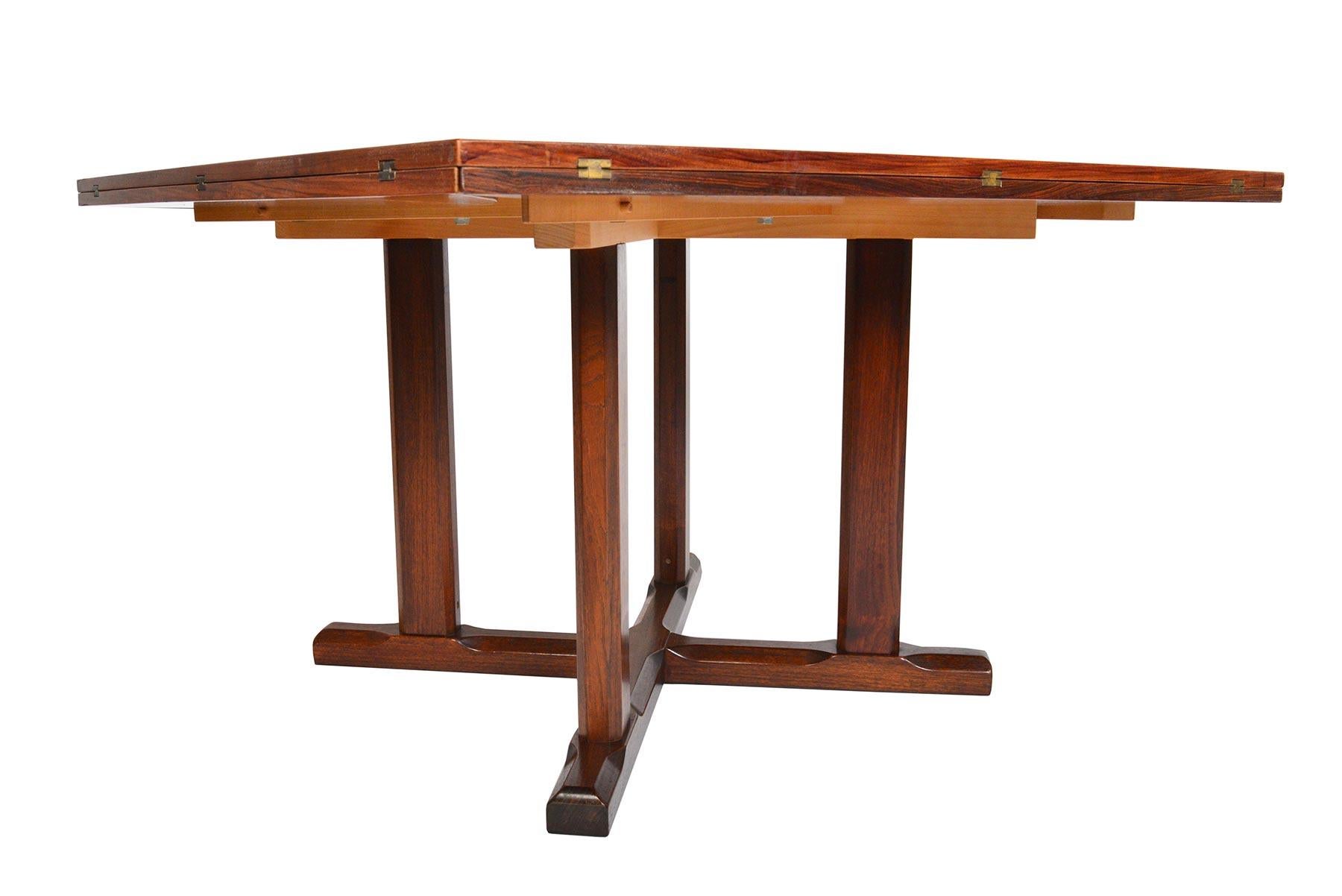 A true shape shifter of design, this Danish modern rosewood dining table by Vejle Stole Møbelfabrik expands and changes form! The square tabletop features triangular rosewood inlays. Each table side offers a hinged leaf supported by sliding runner