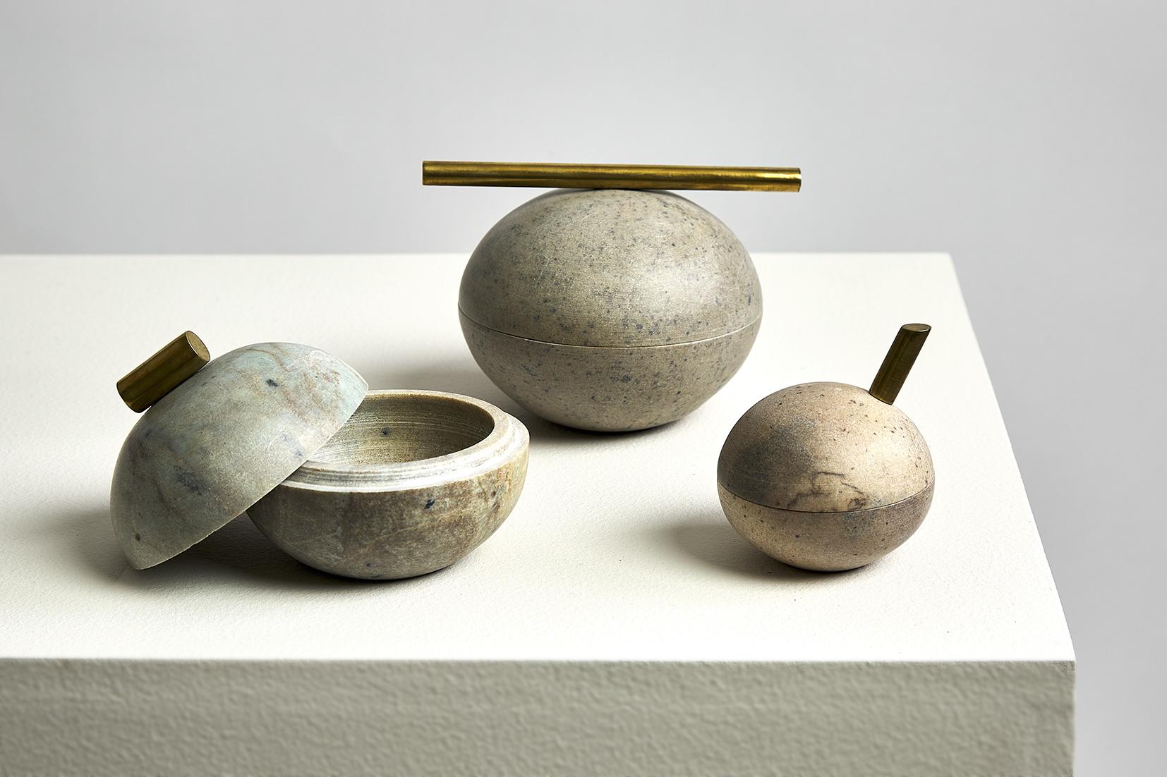 Form and materiality take center stage in these hand-sculpted pots. Bola sabão are small soapstone pots decorated with brass details featuring a rounded shape and fluid color patterns reminiscent of floating soap bubbles. These delicate pots are not