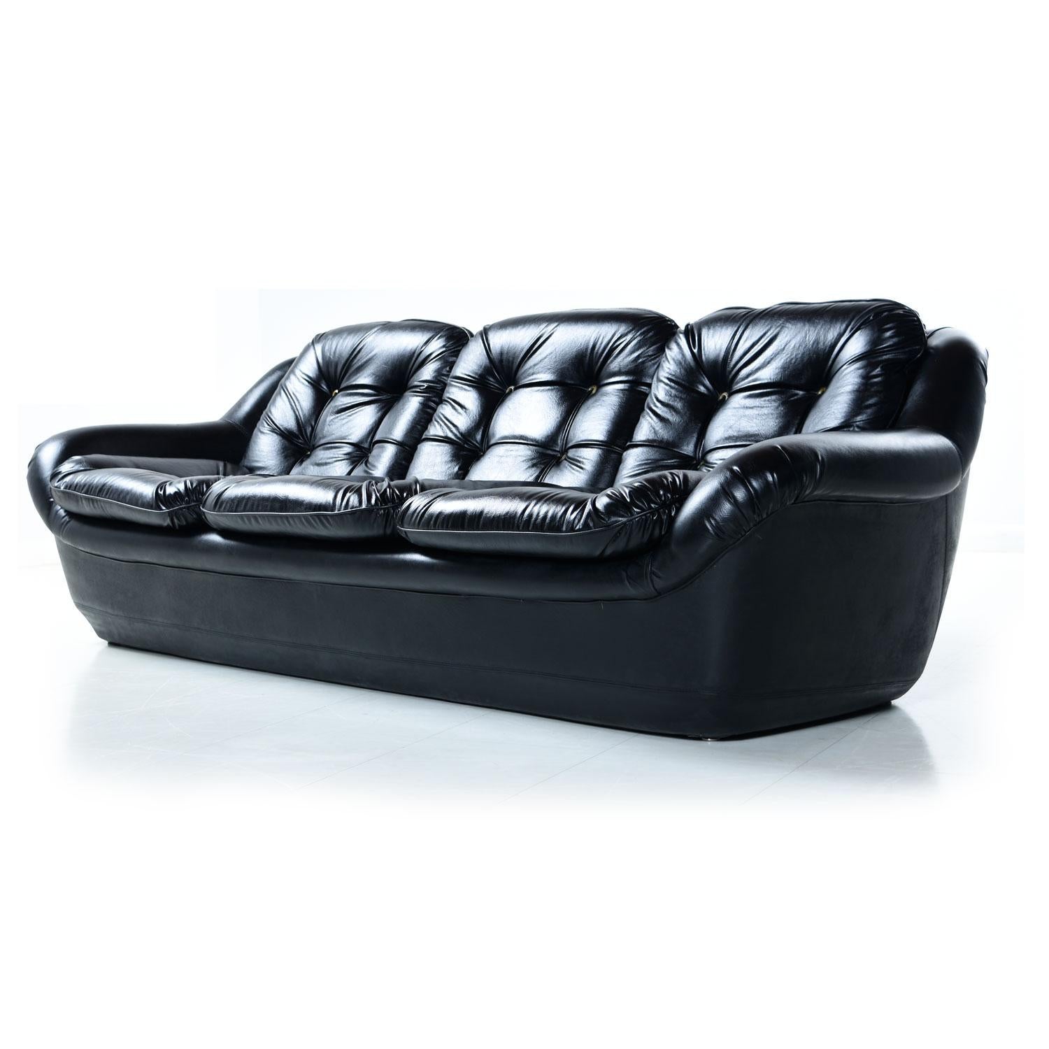 Mid-Century Modern overman pod style molded frame sofa and chair with unique chorded buttons. This magnificent set is all original! The time capsule quality pieces are outfitted in their original black Naugahyde (high quality faux leather vinyl).