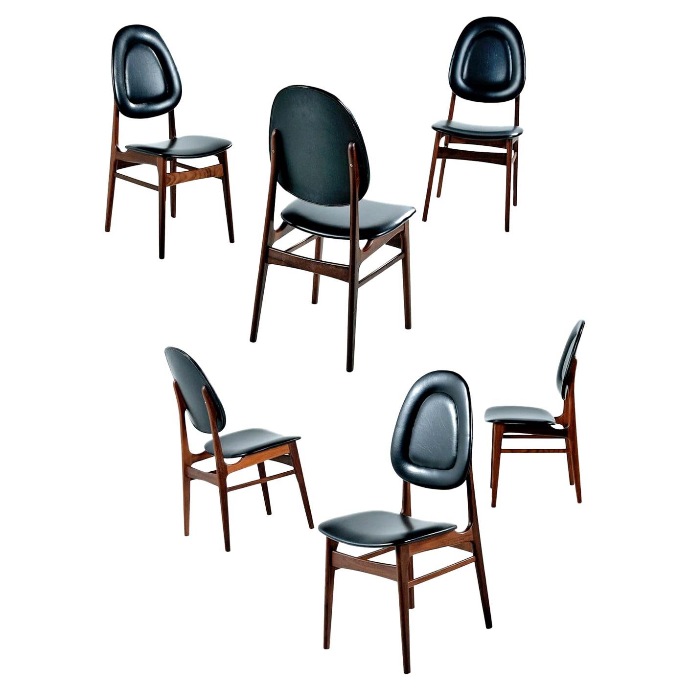 These solid walnut dining chairs by Sørheim are a beautiful example of Classic Norwegian design. The interesting raised edges on the cushions and high backs provide both comfort and character. Don't let these dainty chairs fool you, the elegant