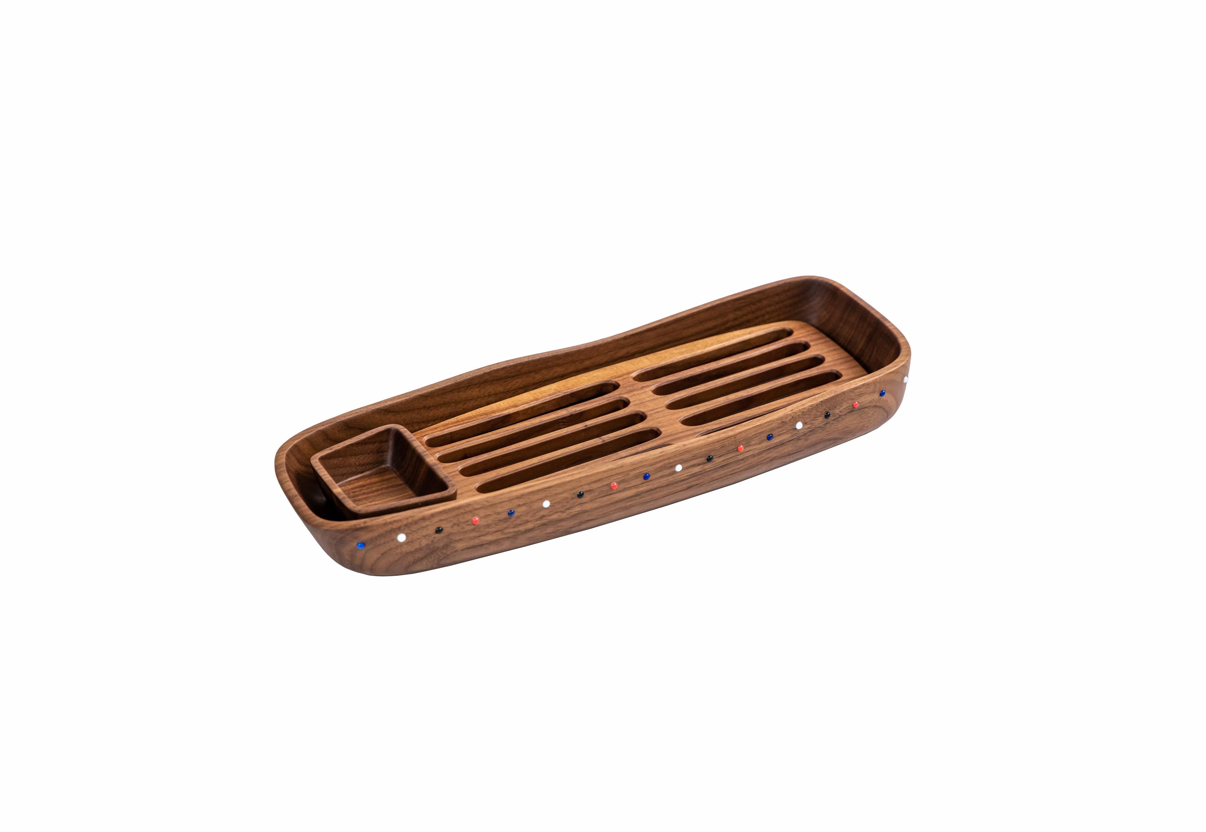The bread board is an organically shaped wooden tray carved from one solid piece of walnut wood. It is beautifully sized with a crumb catcher and a small bowl for olive oil or dips. The embedded glass pearl bead decoration is a signature of the