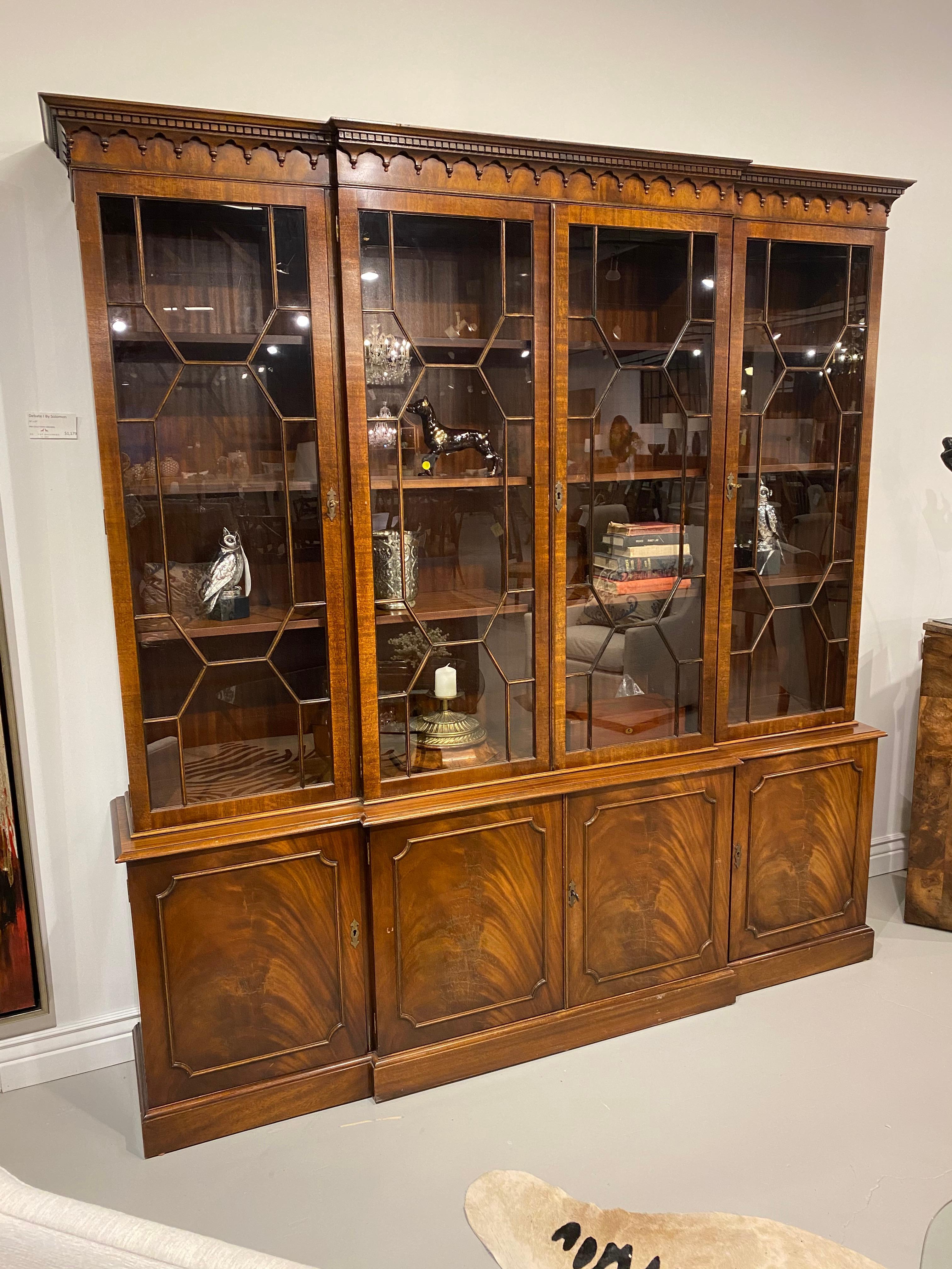 A beautiful full size four-door breakfront bookcase crafted in mahogany, by Bevan Funnel. Adjustable shelves behind the hand glazed upper door, the figured crotch mahogany on the lower doors has a lively grain, that shows slight checking which is