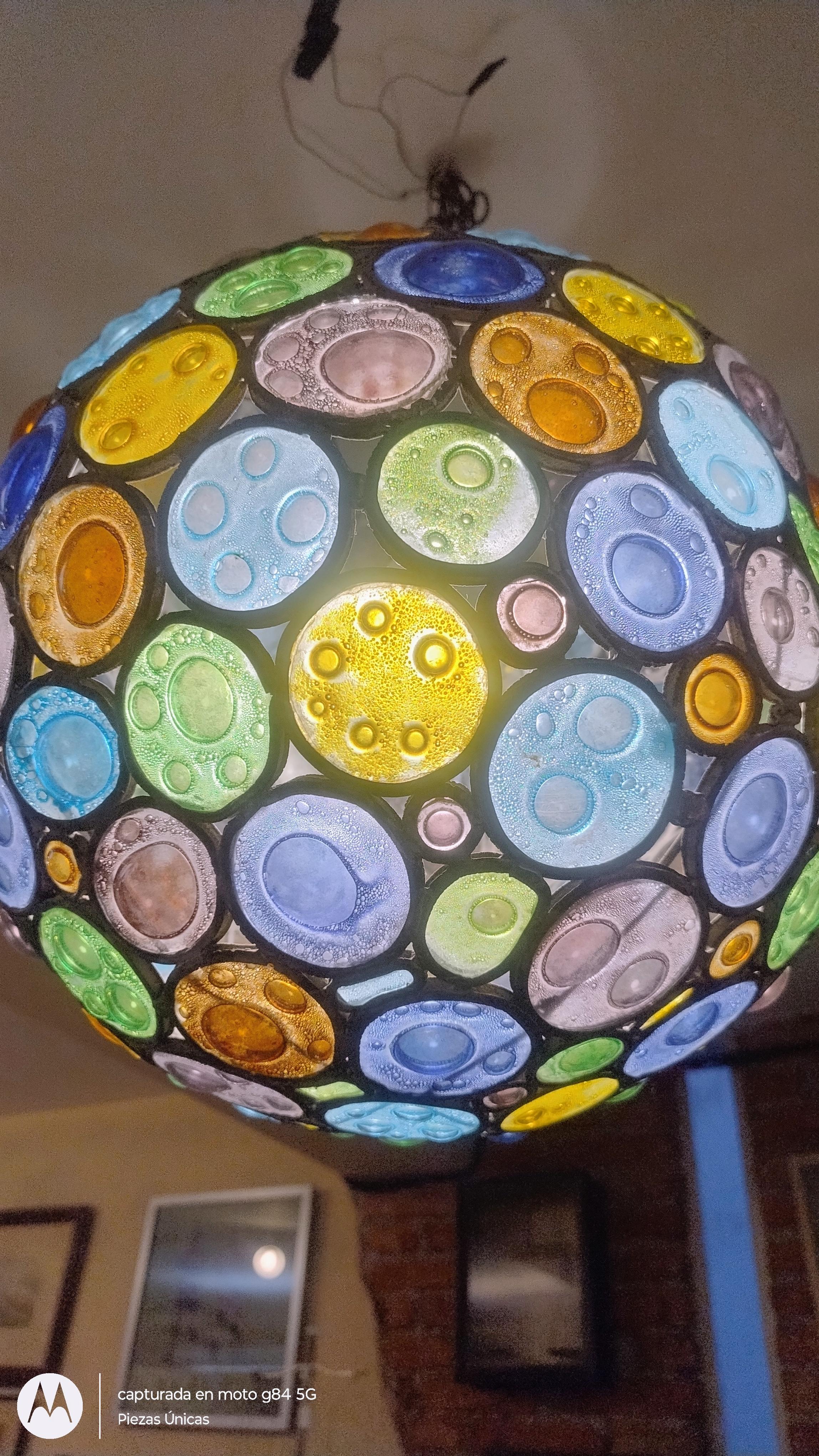 Breath-taking spherical chandelier with a distinctive Mexican mid-century modern style. Constructed with round hand-blown bubbled, textured glass pieces in assorted lively colors, predominantly in the blue, green, and brown hues. This fixture
