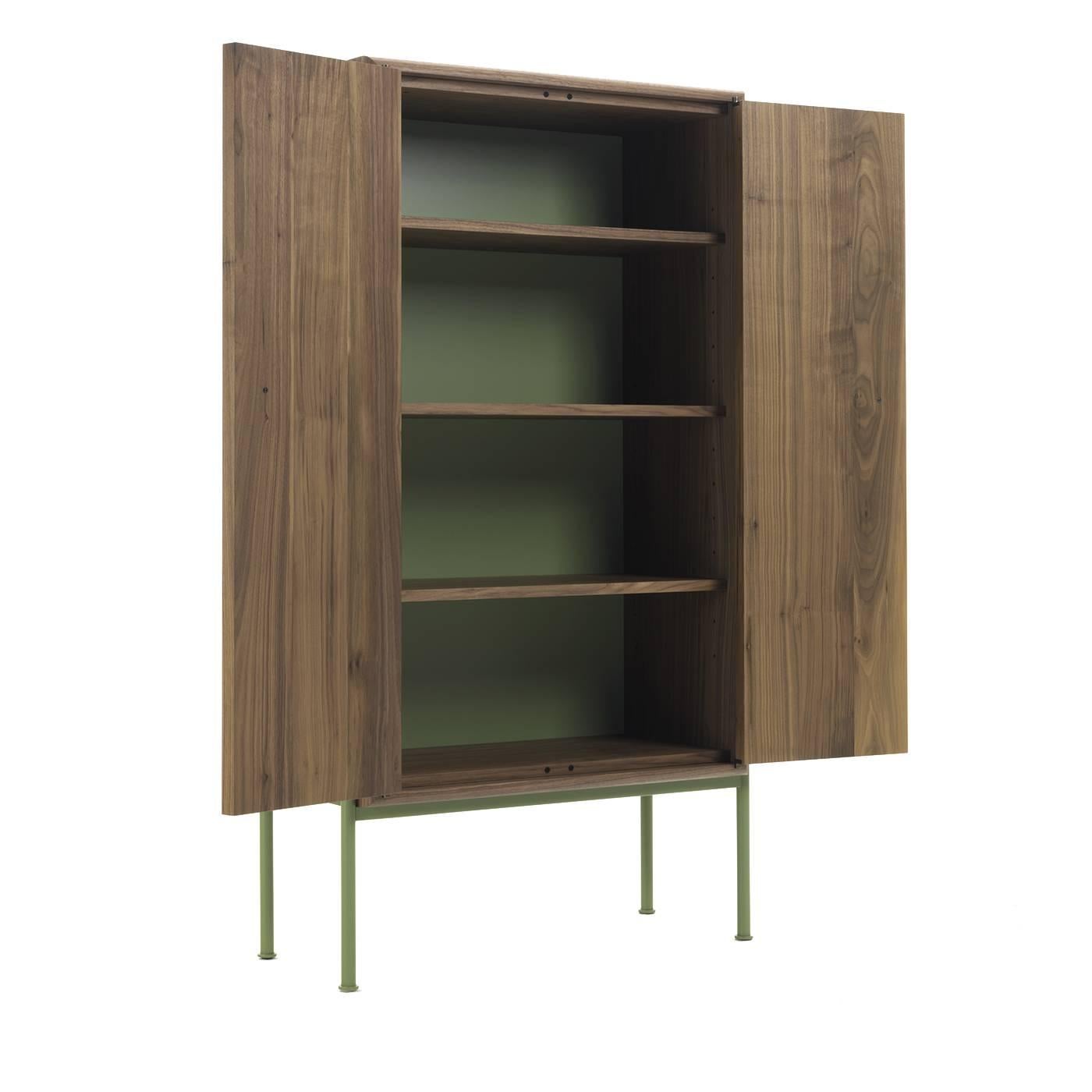 The surface of this imposing cabinet evokes the texture of the skin, whose subtle sensuality transpires from the straight lines and geometric volumes of its Minimalist silhouette. The rectangular body is crafted of Canaletto walnut and rests on an