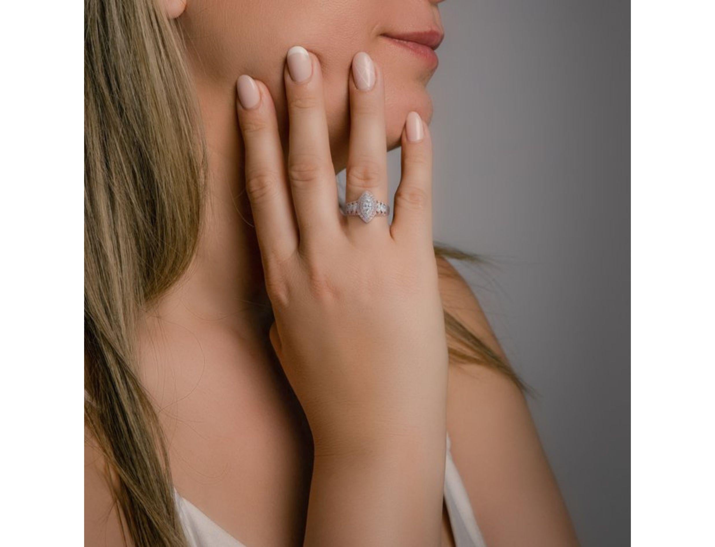 Prepare to be captivated by this ring, a shimmering symphony of light and romance. A breathtaking 0.7 carat marquise diamond, boasting an F color and VS1 clarity, takes center stage, its elongated facets capturing the light with captivating