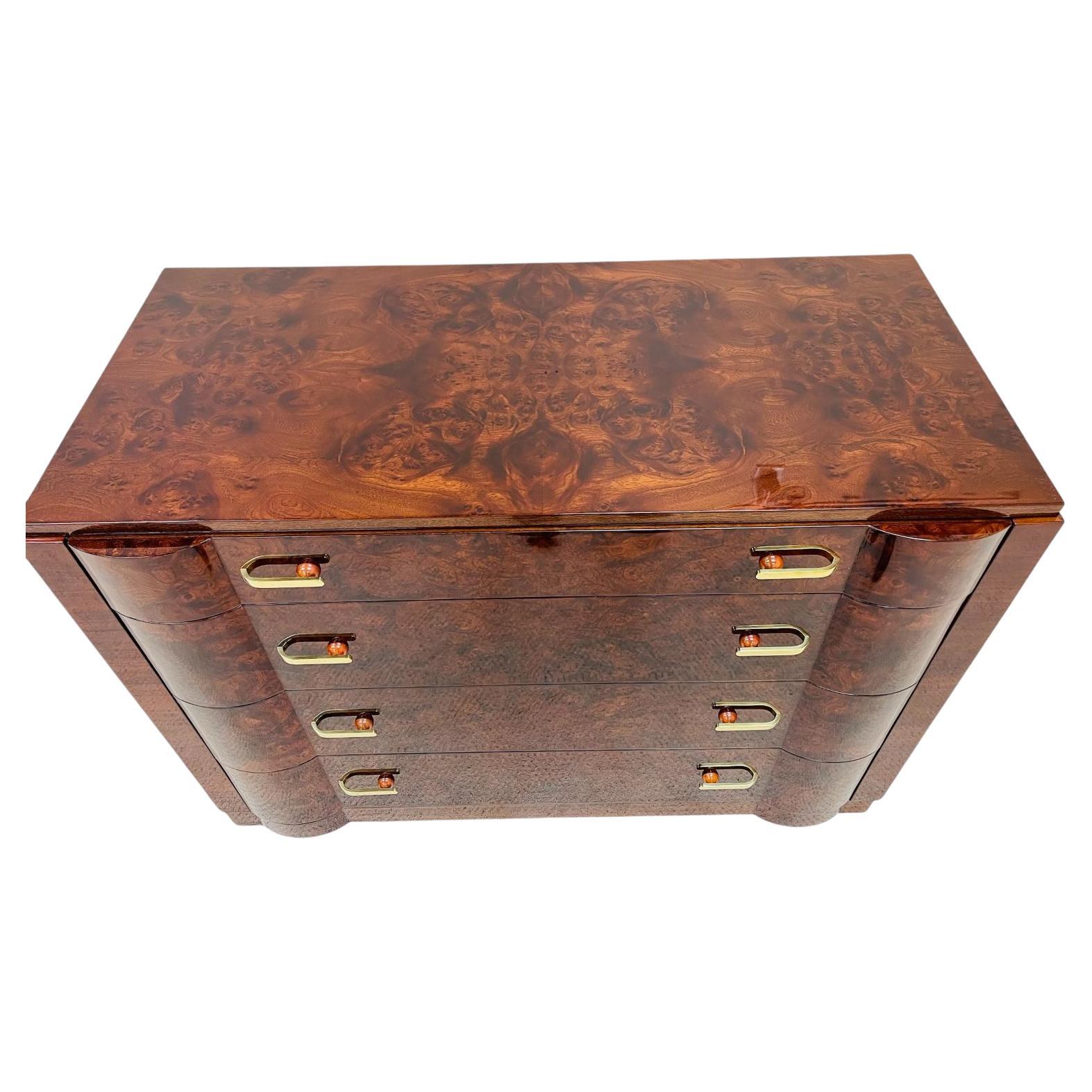 A magnificent example of an American Art Deco burl walnut commode from the Redlion Furniture Company. A fabulous four drawer book match burl wood chest with rare Bakelite and hand polished brass handles. A stunning focal point intended to establish