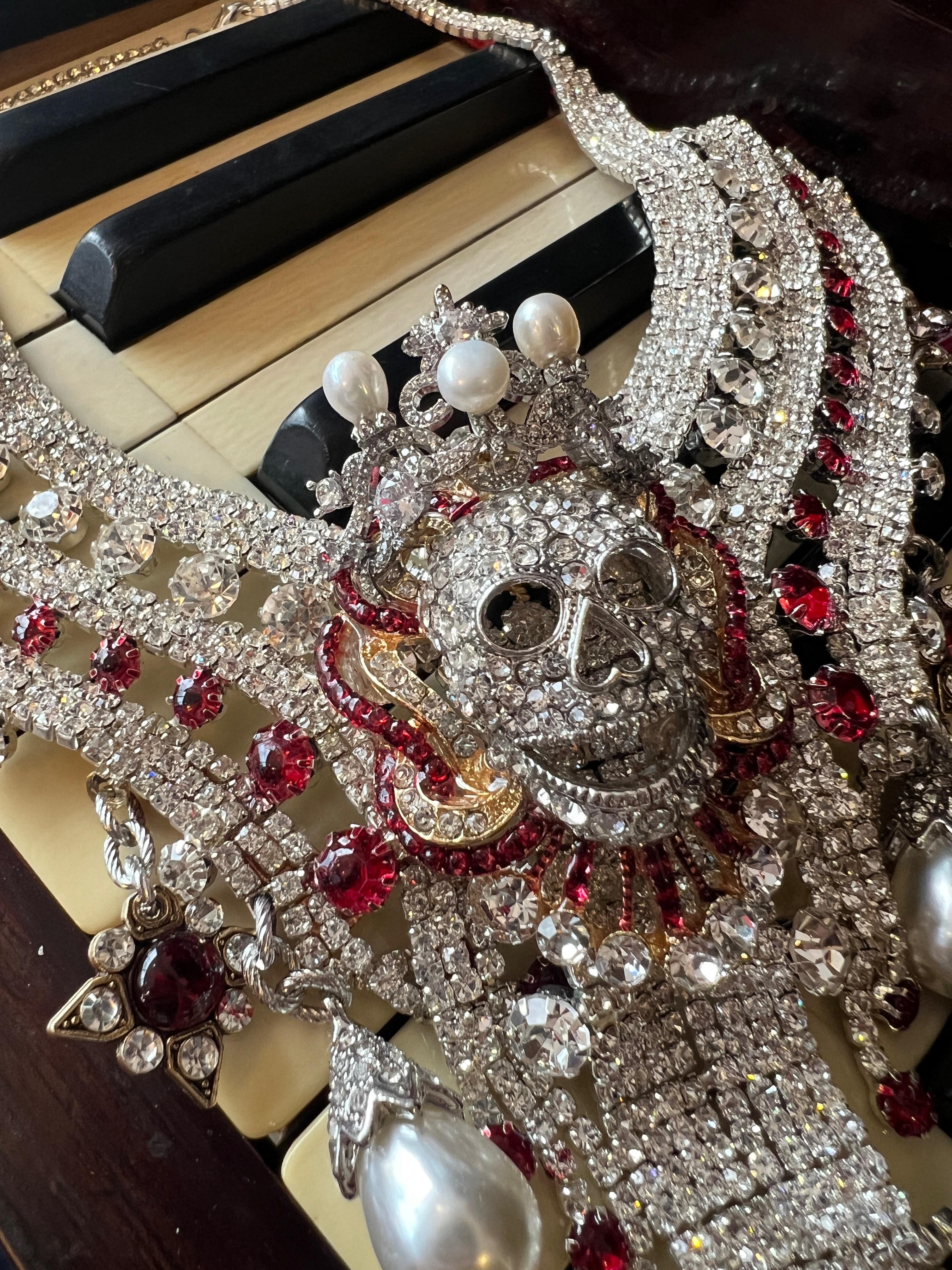 Behold a masterpiece of bold elegance: a one-of-a-kind necklace that commands attention and exudes eccentric charm. Bathed in luxurious yellow gold plating, the necklace shimmers with a dazzling array of Swarovski crystals and rhinestones, creating