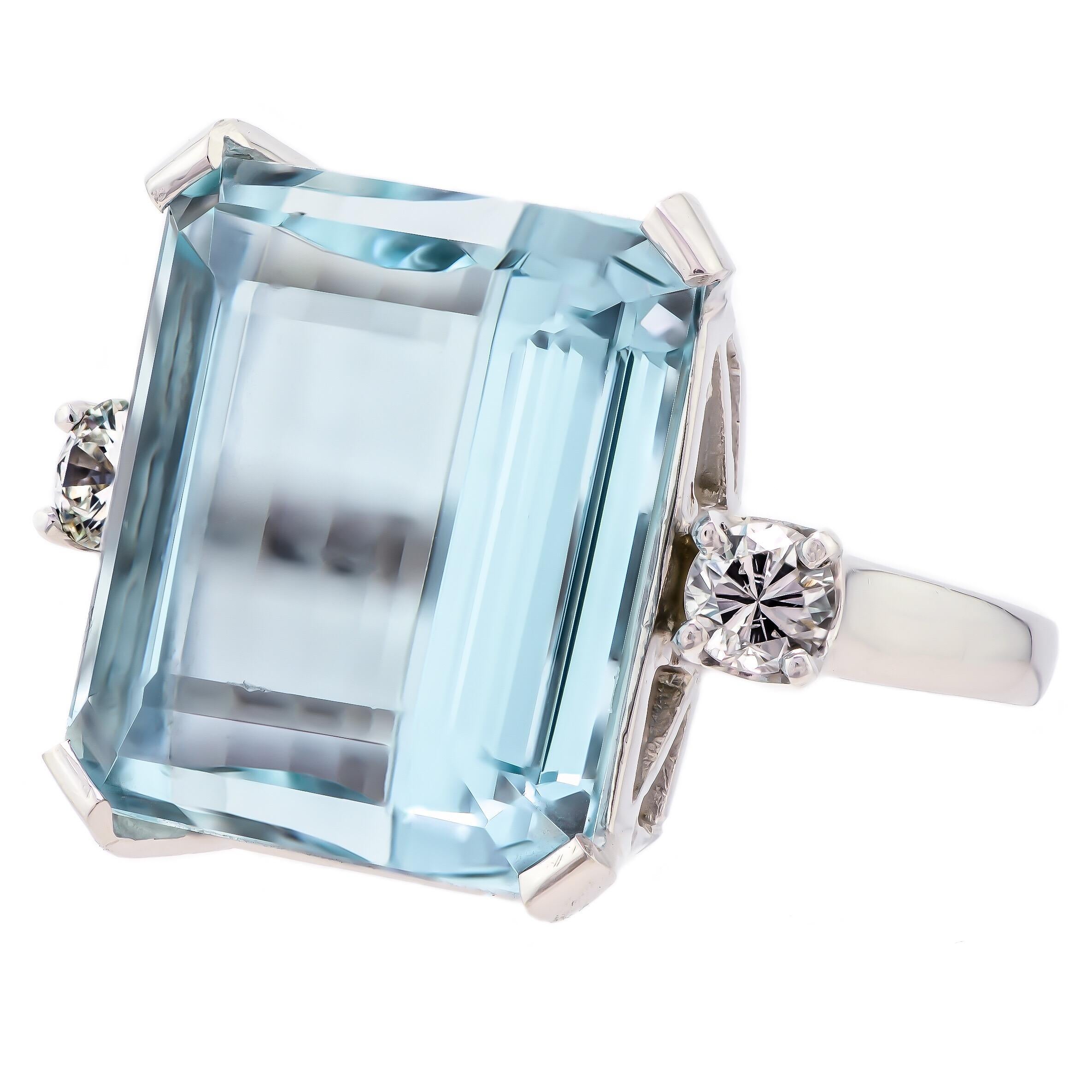 This mid-century cocktail ring is positively exquisite set with one step emerald cut medium-light blue natural aquamarine with the slightest gray/green undertones weighing approximately 18.55 carats is nestled between a total of two (one on each
