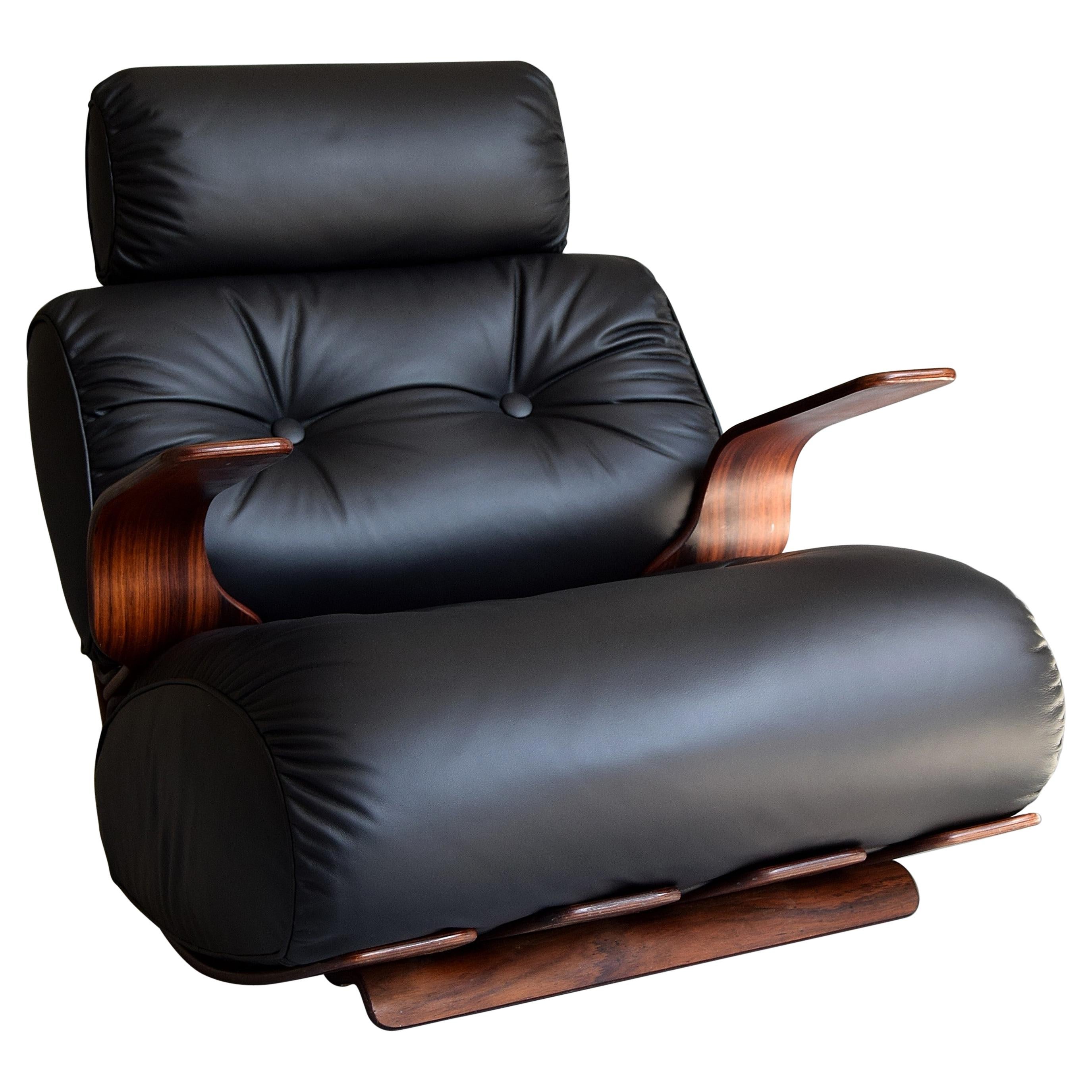 Stilvoller und äußerst bequemer Lounge-/Schaukelstuhl aus den 1970er Jahren. Der Stuhl hat einen raffinierten, gebogenen Sperrholzrahmen mit einem tief und warm gemaserten Palisanderfurnier.
Die neuen, mit hochwertigem, weichem, schwarzem Leder