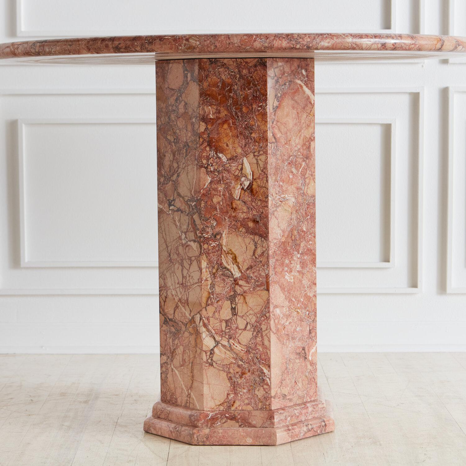 A stunning marble dining or entryway table with a round top resting on a hexagonal mitered edge base with a banded-edge detail. This table is made of Breccia Pernice and features gorgeous pink tones and beautiful marble veining.

This is an item