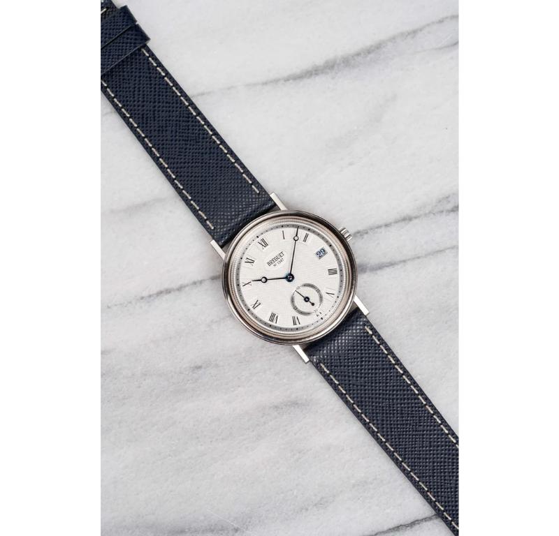 Ecco un Breguet Classique neo-vintage, referenza 5920, con uno splendido quadrante argentato a numeri romani guilloché rifinito a mano, risalente agli anni Novanta. Tiene benissimo il tempo ed è perfettamente funzionante. Le misure includono una