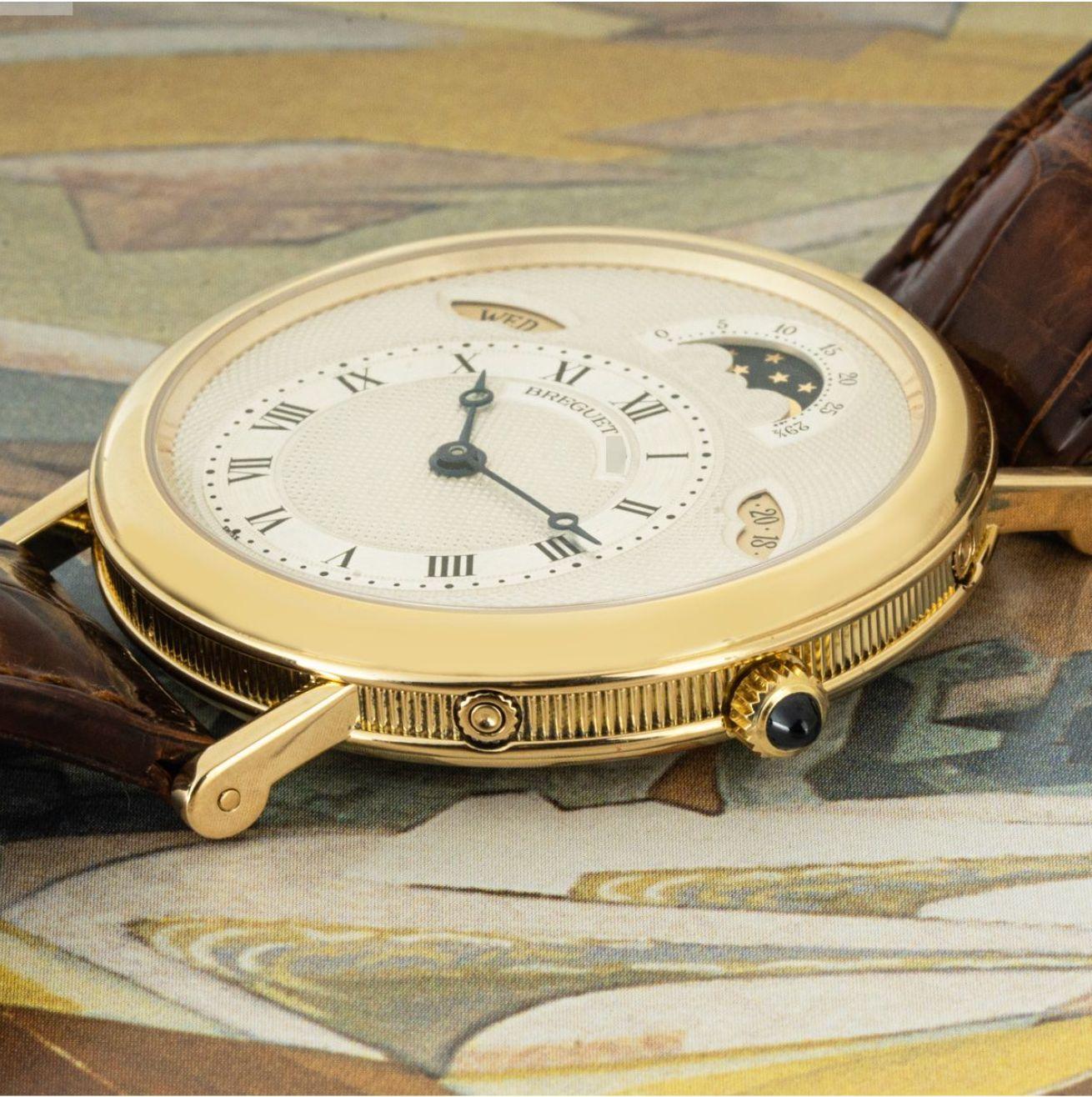 A men's 36mm Classique Calendar by Breguet crafted in yellow gold. Featuring a silver guilloche dial with roman numerals, a day and date aperture as well as a moon phase complication. The watch is also fitted with a sapphire glass, a self-winding
