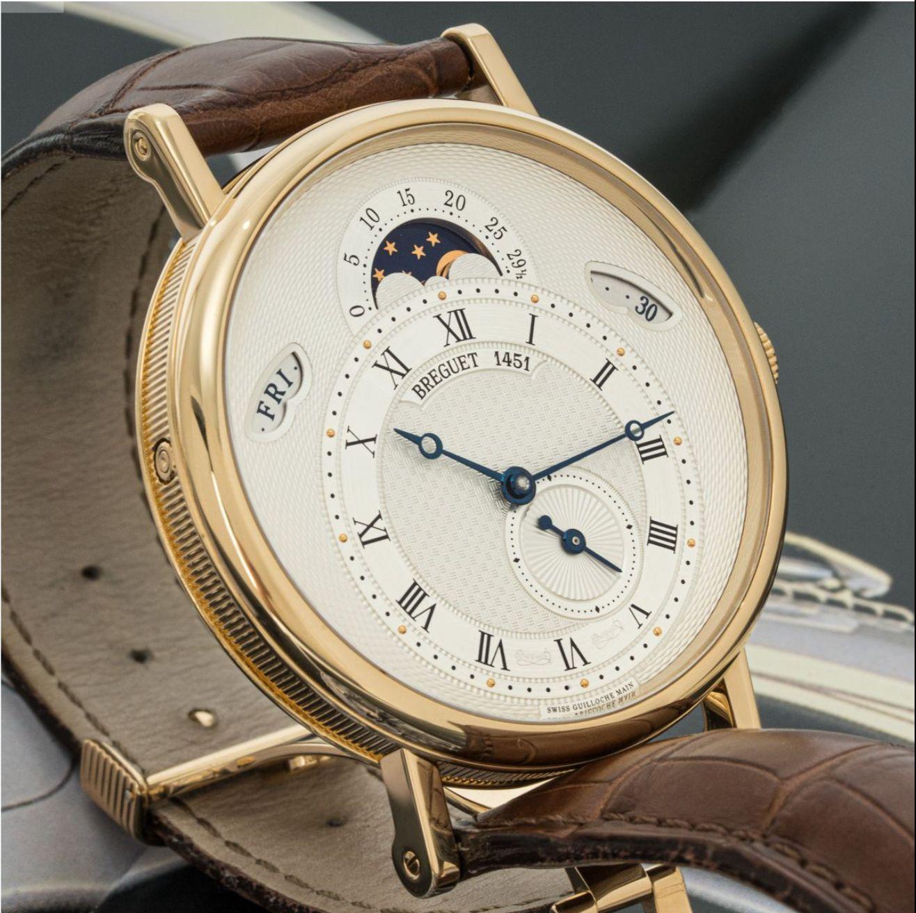 A Breguet Classique Calendrier wristwatch in yellow gold. Featuring a silver guilloche dial with a date, day and moon phase indicator as well as seconds sub-dial. Fitted with a sapphire glass, a self-winding automatic movement and a brown Breguet