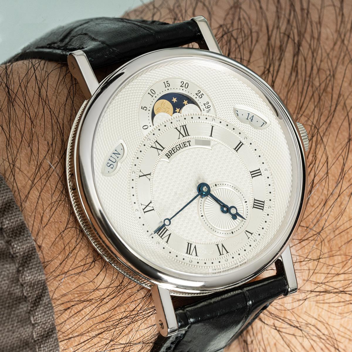 Eine Breguet Classique Calendrier Armbanduhr aus Weißgold. Sie verfügt über ein silberfarbenes guillochiertes Zifferblatt mit Datums-, Wochentags- und Mondphasenanzeige sowie einem Hilfszifferblatt für die Sekunde. Ausgestattet mit einem Saphirglas,