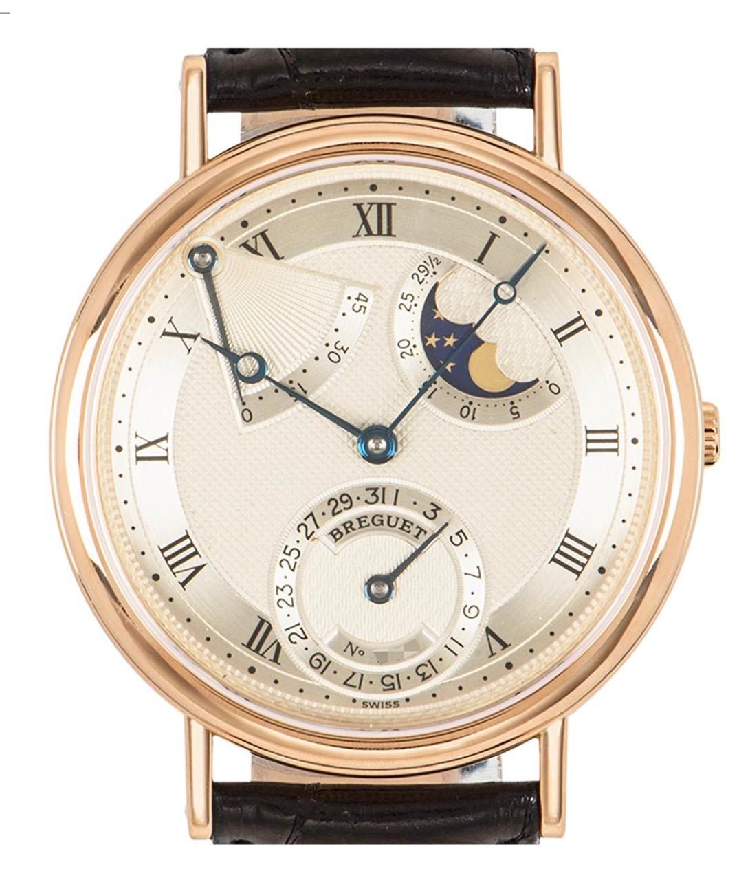 A men's Classique wristwatch crafted in rose gold by Breguet. Featuring a silvered dial with a textured guilloche pattern, a power reserve as well as a moon phase indicator. The watch further features a smooth fixed yellow gold bezel with a coin