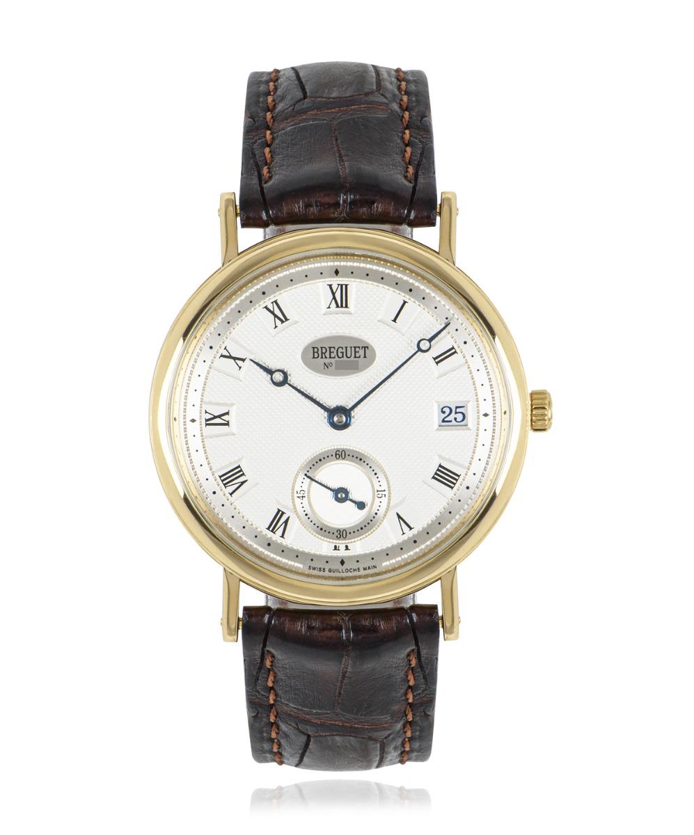 A Classique in yellow gold by Breguet. Featuring a silvered gold guilloche dial hand engraved on a rose engine. The dial also features a date display, small seconds and blued steel Breguet hands. The brown leather strap is generic but does come with