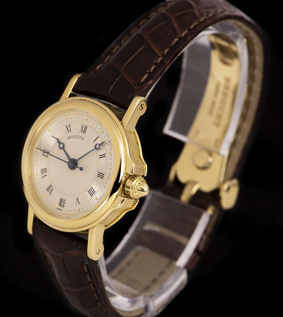 An 18k Yellow Gold Horologer De La Marine Ladies Wriswatch, silvered dial hand engraved on a rose engine with roman numerals, date at 6 0'clock, a fixed 18k yellow gold bezel, a brand new original brown leather strap with an original 18k yellow gold