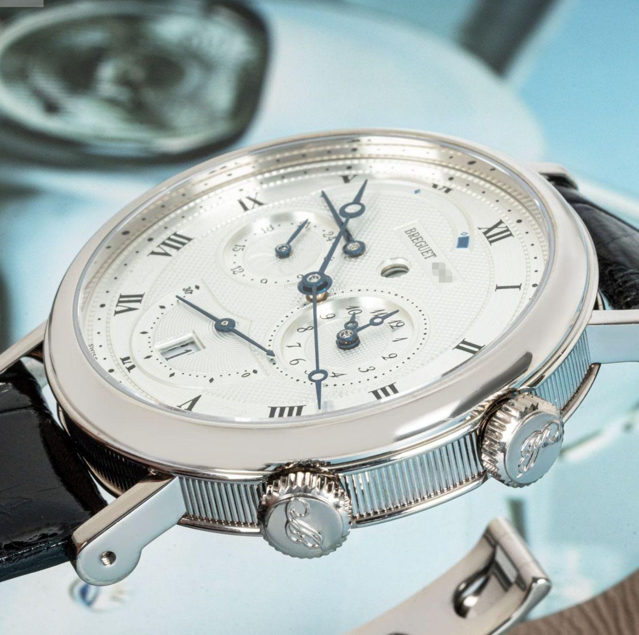 A white gold Le Reveil Du Tsar Classique wristwatch by Breguet. Featuring a silver dial with roman numerals and a date display. The watch also features a small second sub-dial, a second-time zone, a power reserve indicator and an alarm that can be