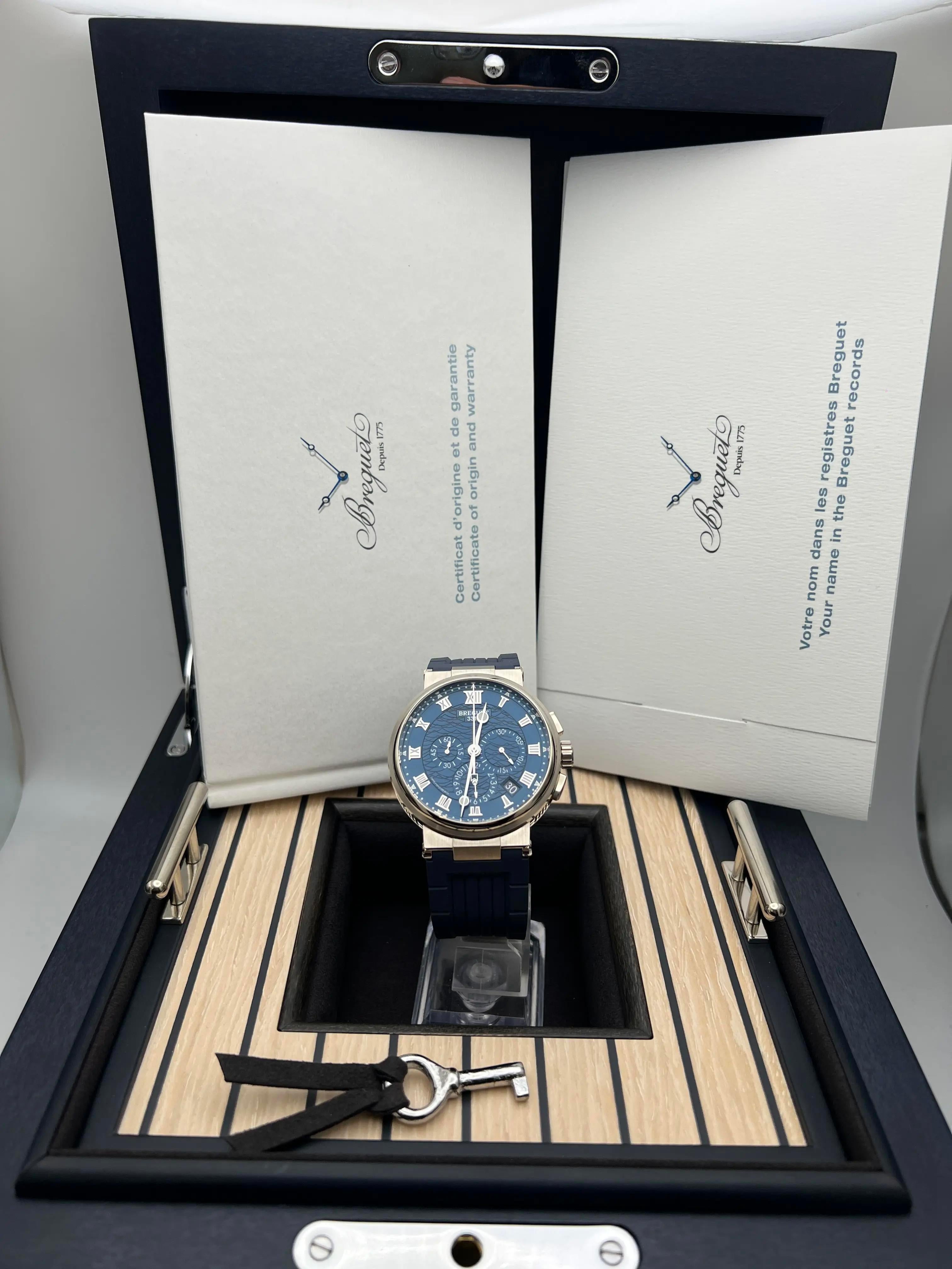 Breguet Marine Chronograph 5527BB/Y2/5WV, mit einem 42,3 mm großen Gehäuse aus 18 Karat Weißgold mit gebürsteter und polierter Oberfläche. Das auffallend blaue Zifferblatt zeigt ein Sonnenschliff-Muster mit applizierten römischen Ziffern,