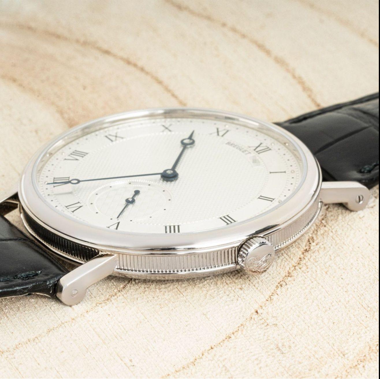 Une montre-bracelet Breguet Classique en or blanc. Whiting : cadran argenté avec motif guilloché texturé, petite seconde et lunette en or blanc.

Équipé d'un bracelet en cuir noir Beguet et d'une boucle ardillon en or blanc. La montre est également