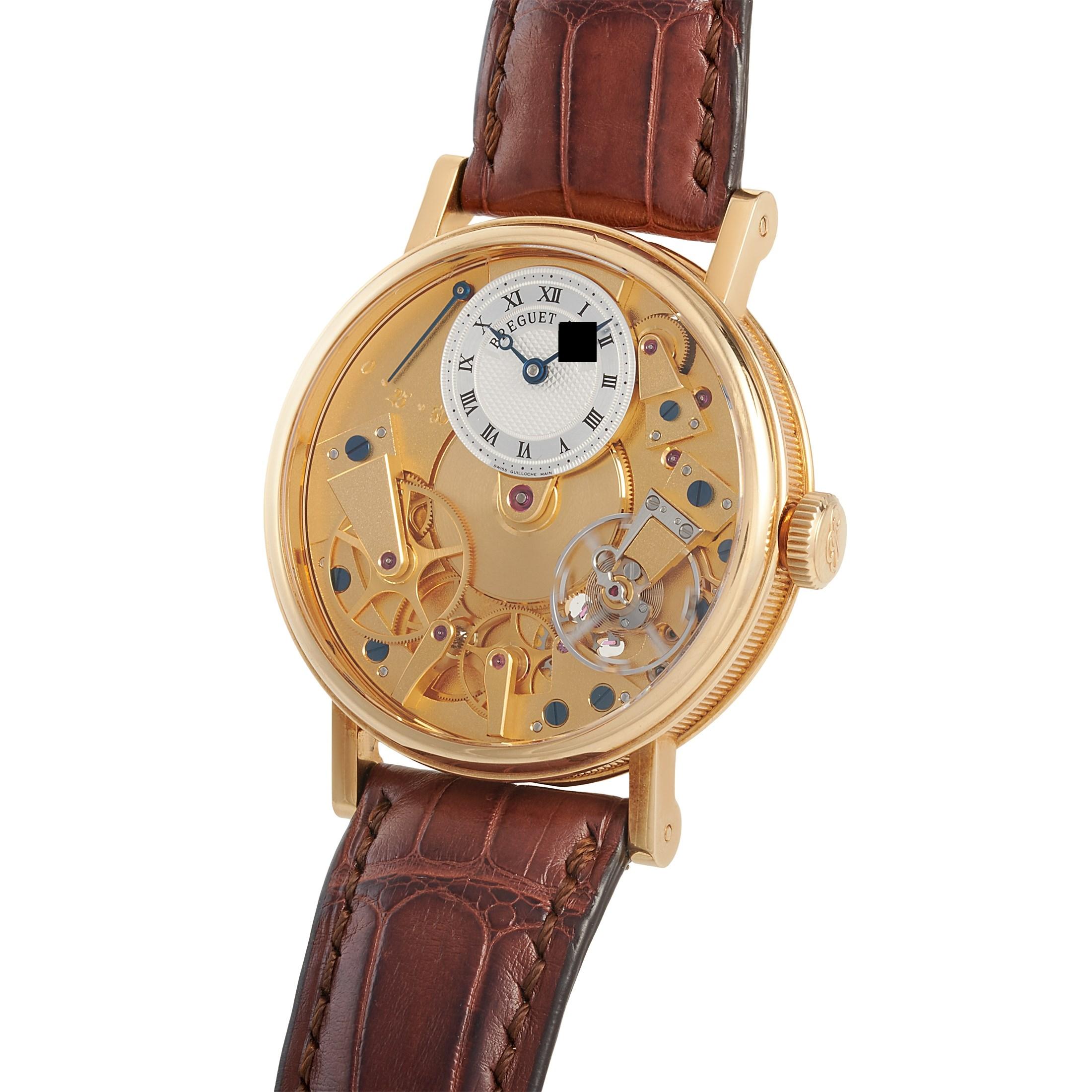 The Breguet Tradition watch, reference number 7027BA/11/9V6, is presented with an 18K yellow gold case that boasts transparent back. The case measures 37 mm in diameter and is mounted onto a brown leather strap, secured on the wrist with a tang