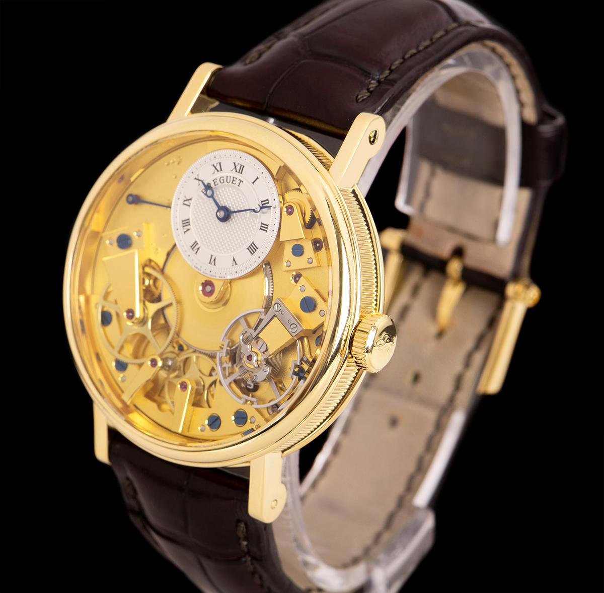 An 18k Yellow Gold Tradition Gents Wristwatch, champagne open worked dial with an off-centred silver guilloche dial hand engraved on a rose engine with roman numerals, power reserve indicator between 9 and 11 0'clock, blued steel Breguet open-tipped