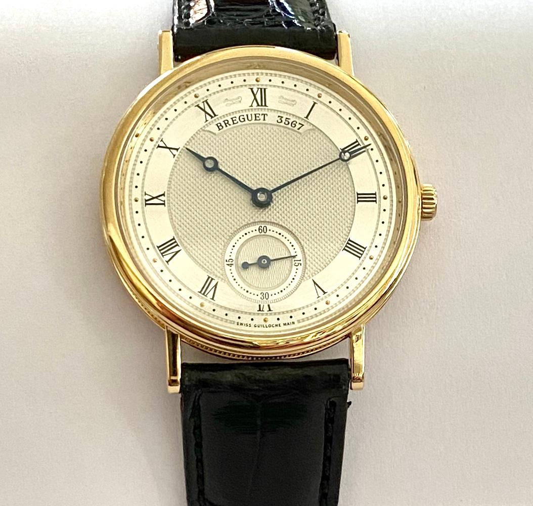 One (1) 18K. Yellow Gold Breguet Wirstwatch with a Hand - Wound Movement, water resistant to 30 M (100 feet)   35mm.  High:  7 mm.  Weight (total)  57.77 grams
Molel: 