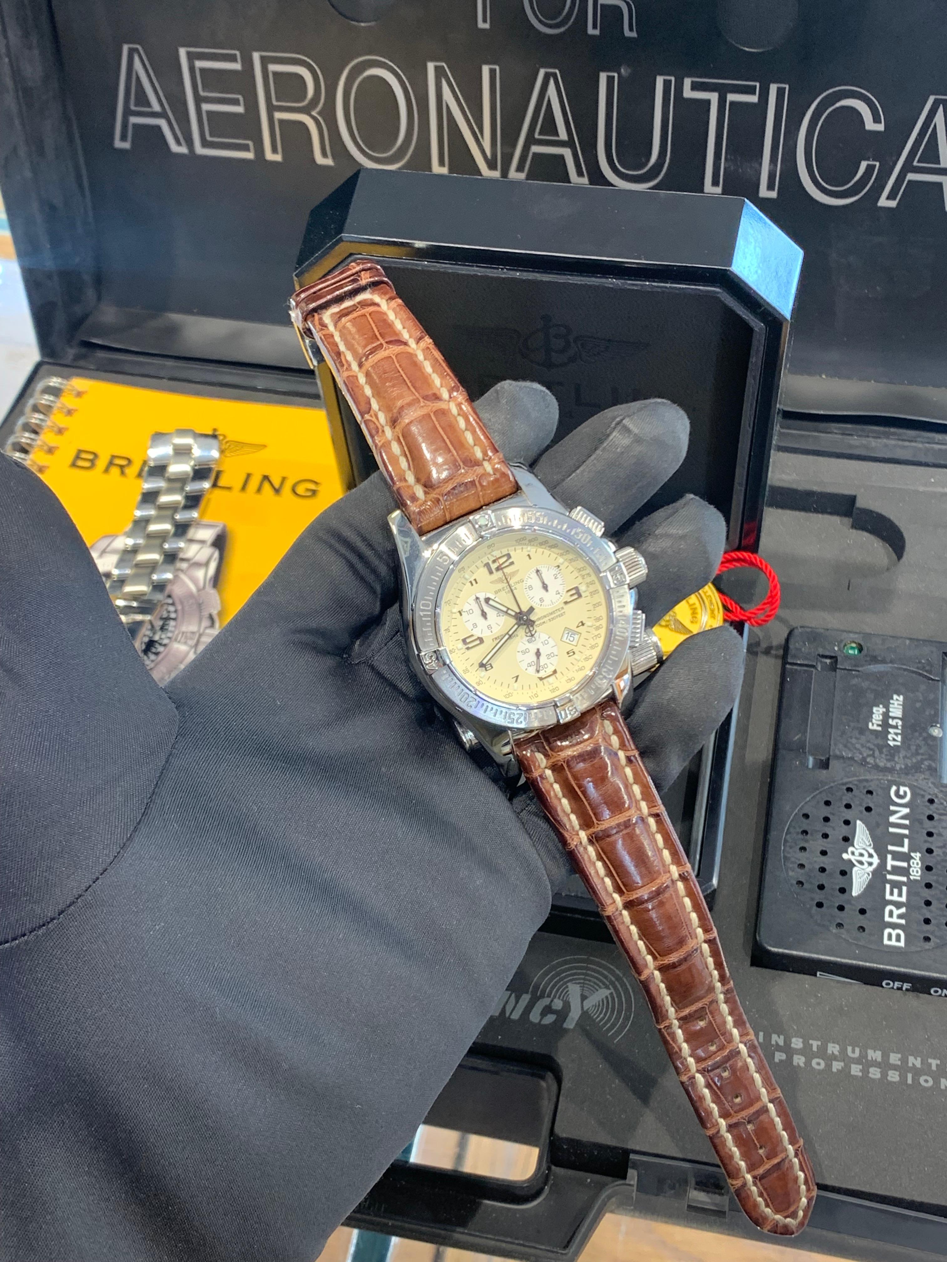 Breitling Emergency Mission, Swiss Made, In (Full) Stainless Steel. 
Beautiful Cream Dial.
The Watch Is In Perfect Condition, Barely Ever Been Worn.
Comes on a Brown Leather Strap Made By “Breitling”, as Well as a Stainless Steel Bracelet Made For