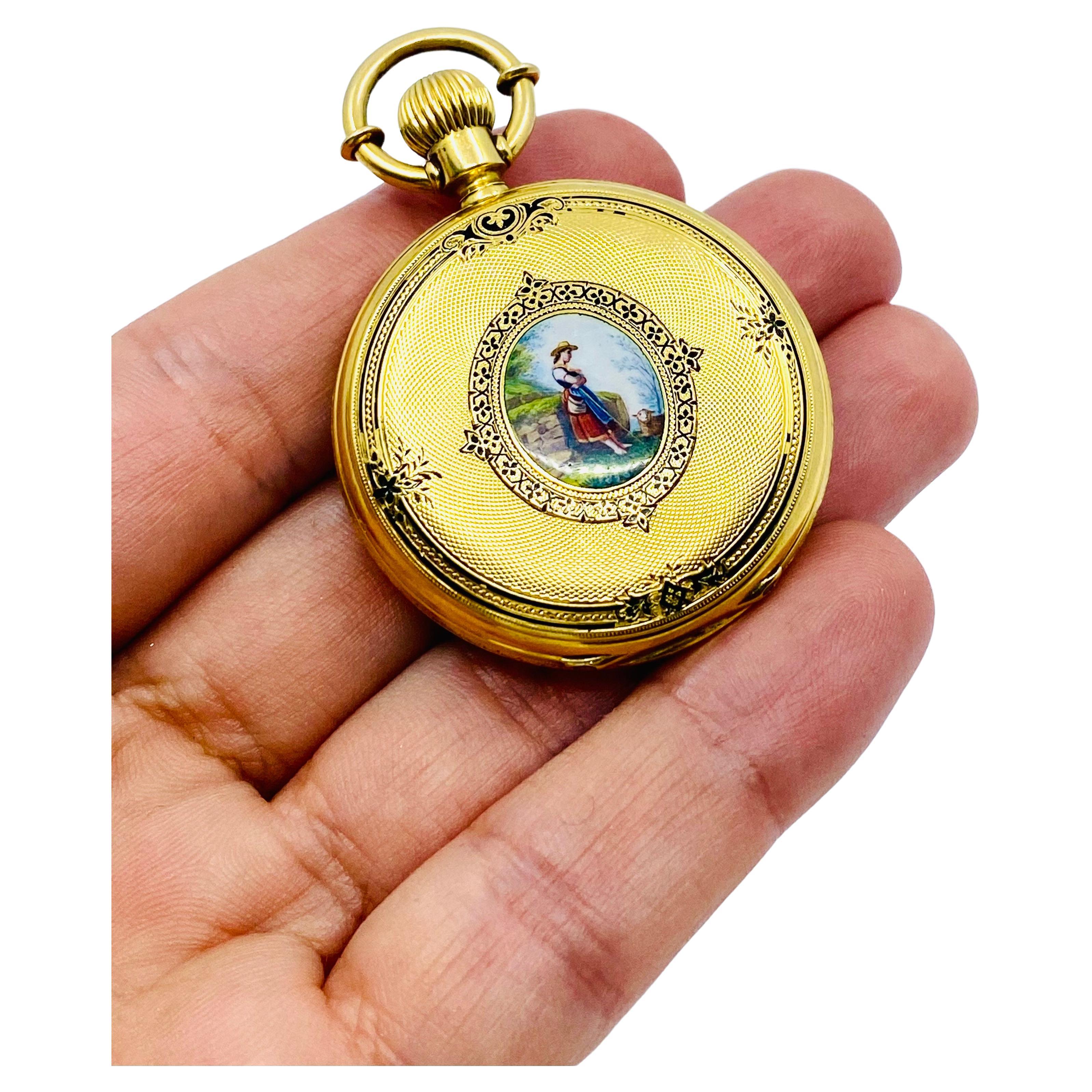 
Une étonnante montre de poche ancienne Breitling Laederich, datant de la fin des années 1800. La montre est en or 18 carats et comporte des émaux.
La montre est logée dans un magnifique boîtier de chasseur décoré de deux miniatures en émail. Une