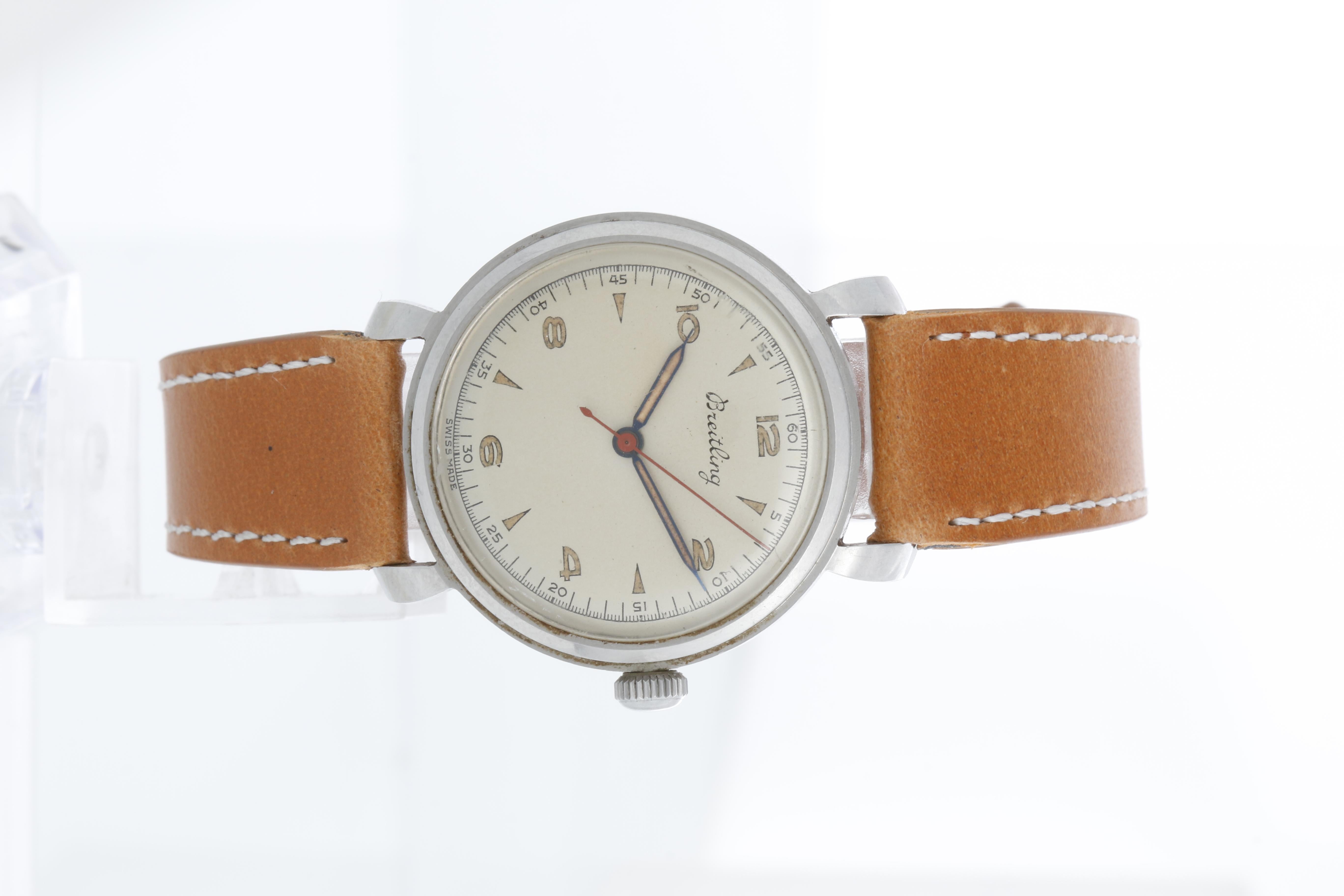 Breitling Stainless Steel Silver Dial Mens Watch Ref 123 - Manual winding. Stainless steel case; unpolished ( 34 mm }). Beautiful silver dial with Arabic and arrow markers; Signed Breitling.. Brown leather band with tang buckle. Pre-owned with