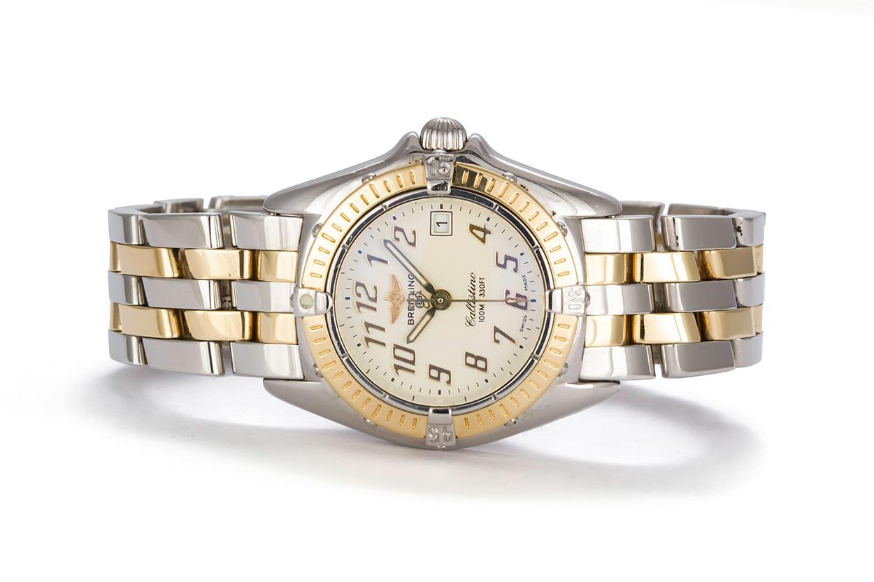 We are pleased to offer this Breitling Callistino Watch D52045. This watch features a solid 18k yellow gold and stainless steel two tone design with a quartz movement and off white cream dial. the case is 27mm and the watch will fit a wrist up to
