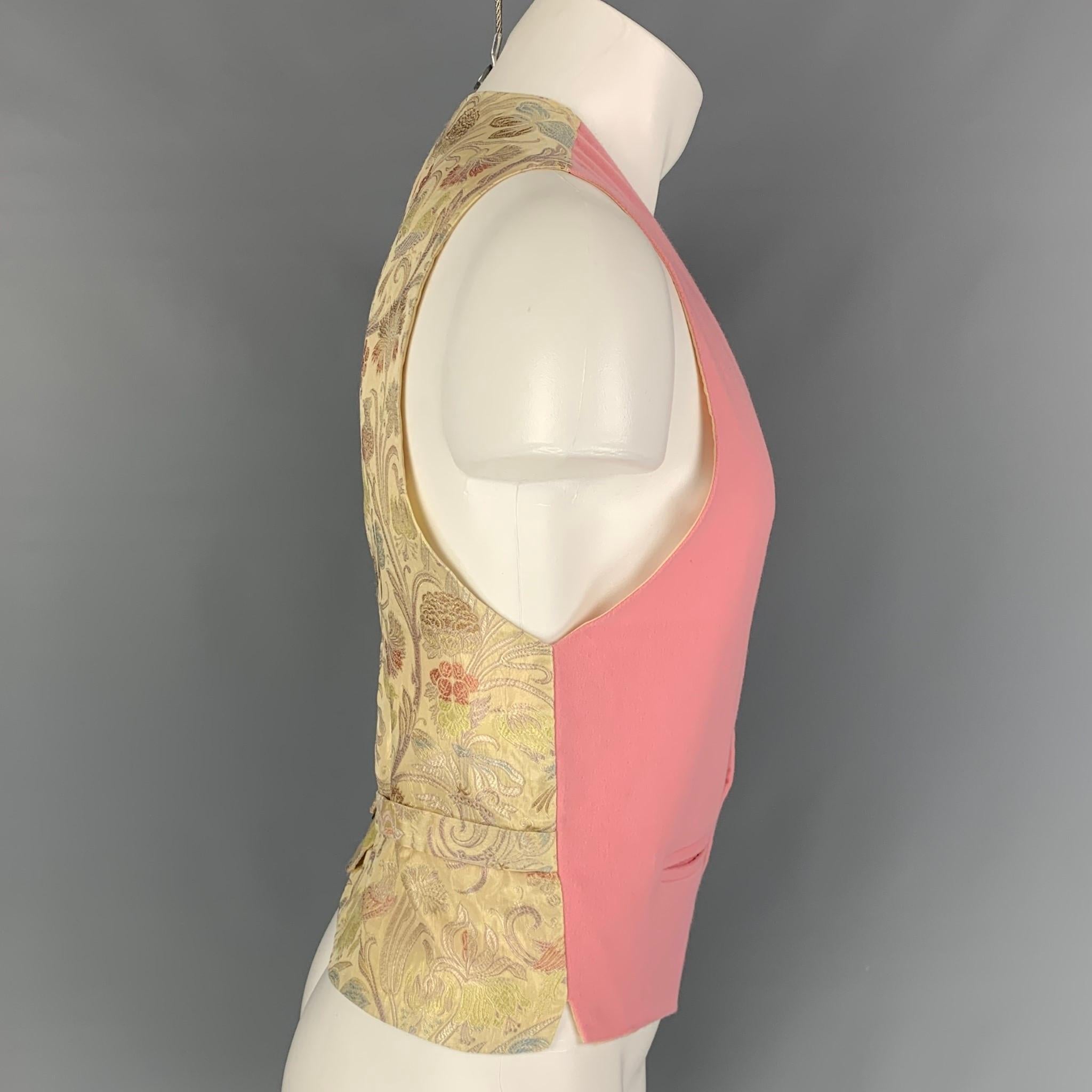 BRENDA KETT vest comes in a pink & beige cashmere with a silk jacquard back featuring a back belt, slit pockets, and a buttoned closure. Made in USA.

Very Good Pre-Owned Condition.
Marked: M

Measurements:

Shoulder: 13.5 in.
Chest: 41 in.
Length: