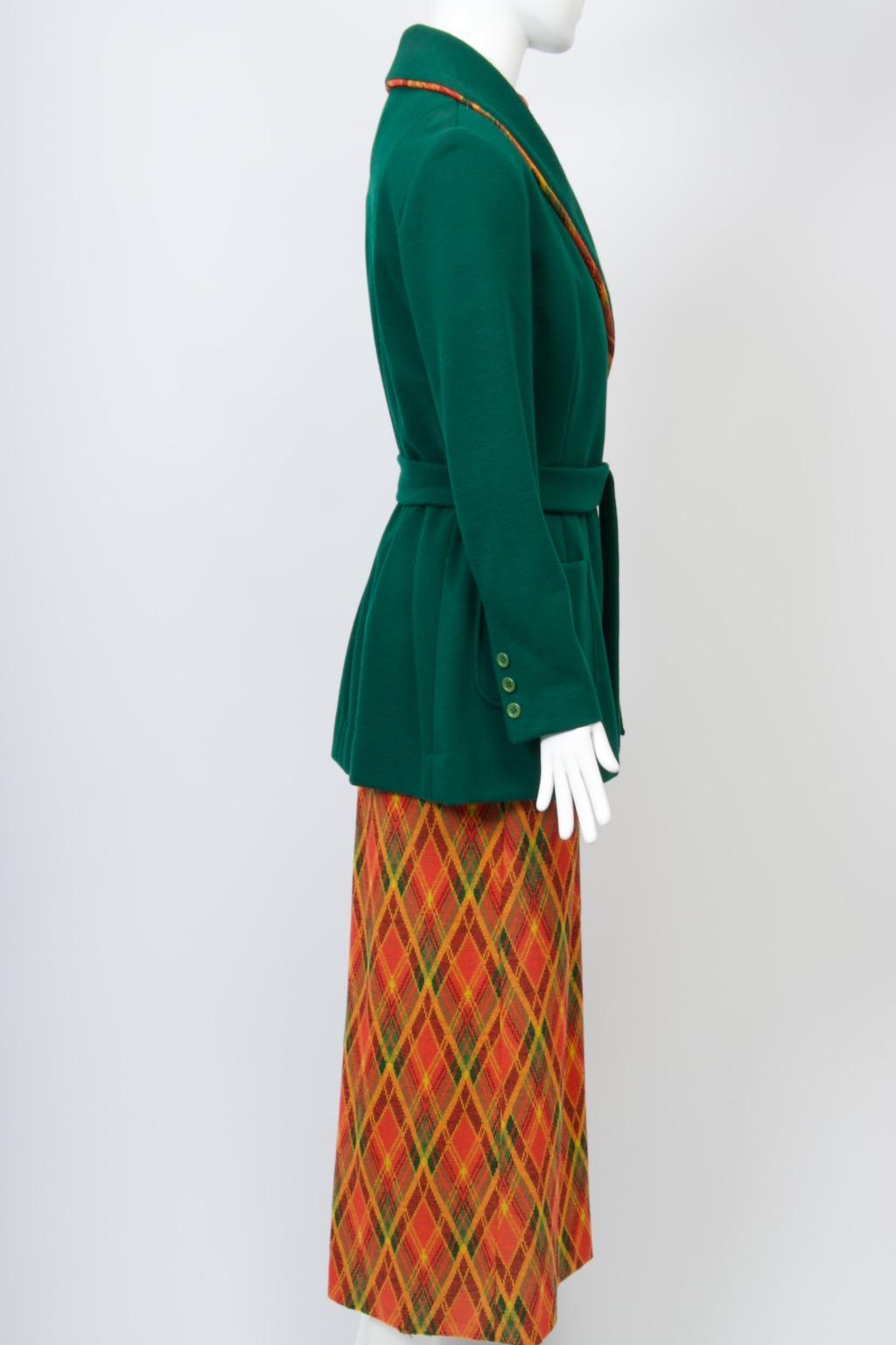 Brenner Couture 1970s unusual knit ensemble consisting of a plaid maxi dress under a forest green jacket. The sleeveless dress features a mandarin collar, deep side slit, and back zipper. Covering the dress is a smoking-style wrap jacket, the