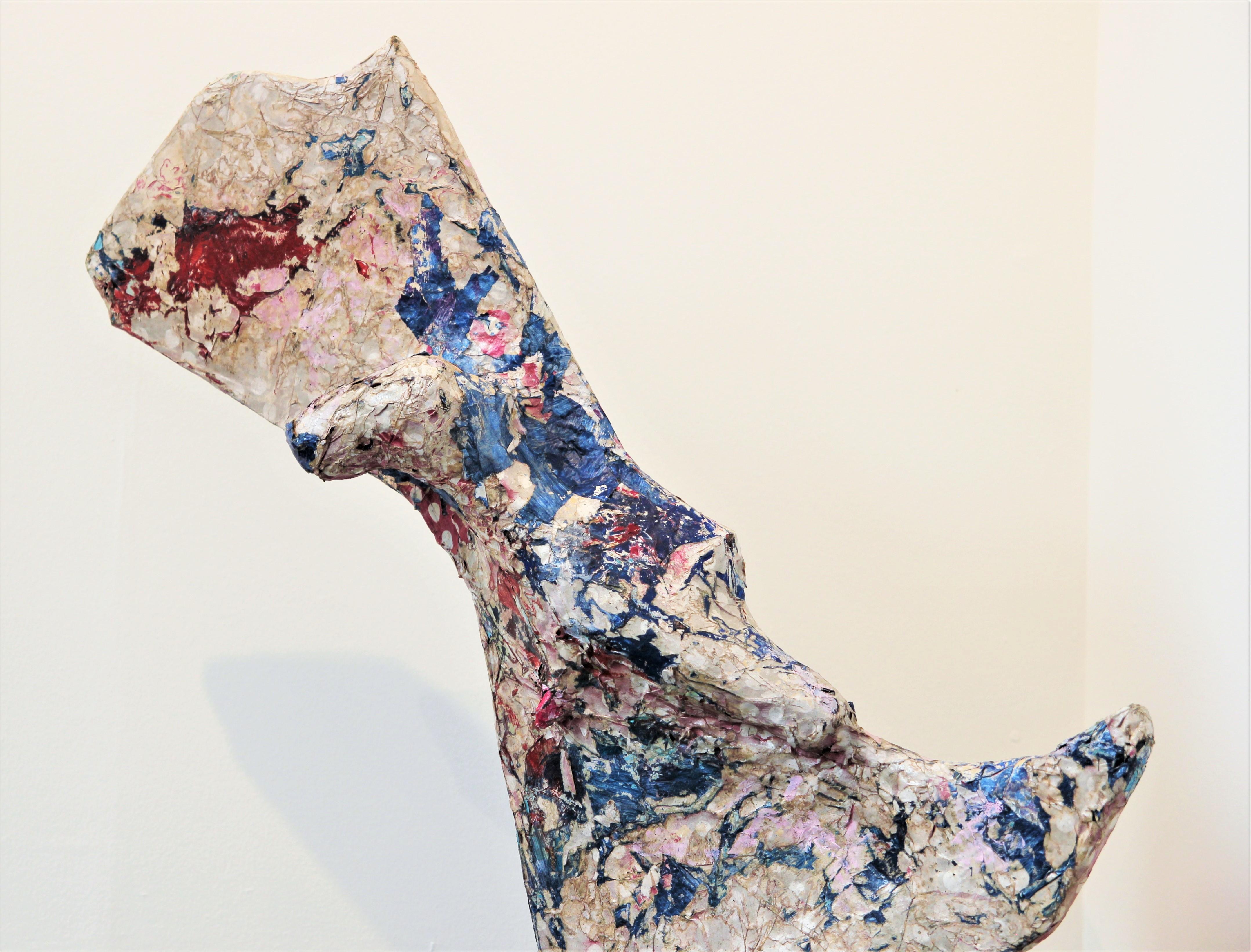 Red and blue abstract contemporary collage sculpture that incorporates wrapping paper, cardboard, wood, acrylic paint, and wood glue. The organic, amorphous form features a primarily white surface with accents of bright reds, blues, and pinks.