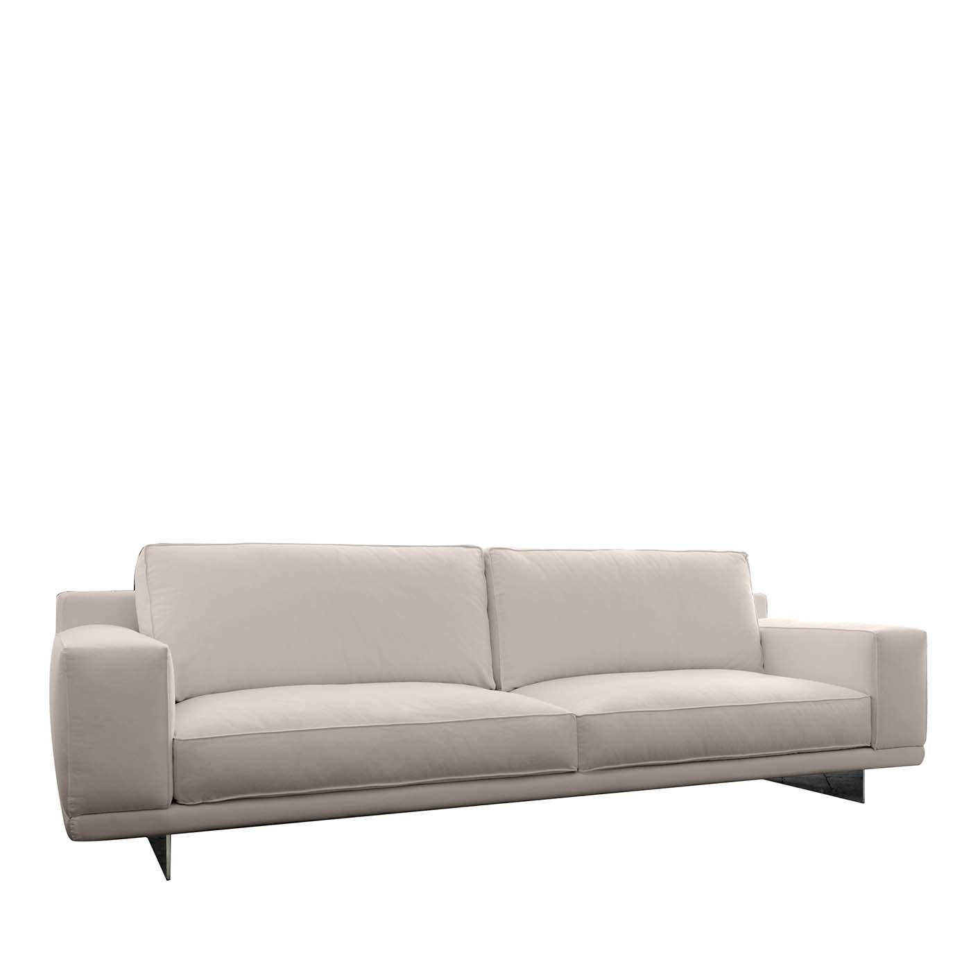 Revisiting traditional lines with a modern look and a constant eye on comfort, this slender sofa is raised on a platform supported by two steel rectangular legs with a white finish (also in polished chrome) to complement the white Dacron upholstery.