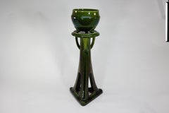 Bretby. An Arts and Crafts green planter and stand both stamped Bretby.