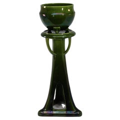 Bretby. An Arts and Crafts green planter and stand both stamped Bretby.