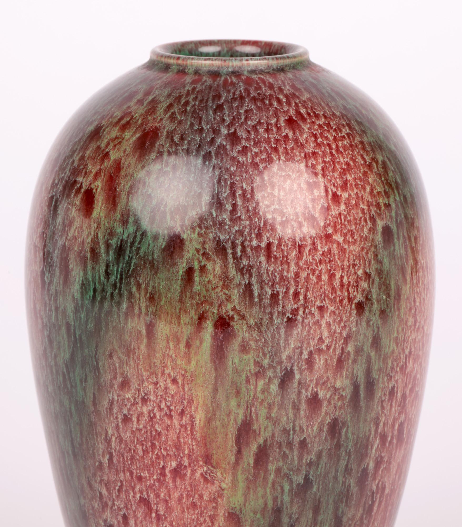 A rare Bretby Art Nouveau high fired ‘flambe’ glazed art pottery vase by Henry Tooth & Co and dating from 1900-1910. This exquisite simple shaped bulbous vase stands on a narrow round foot and is of tall shape widening with a narrowing shoulder and