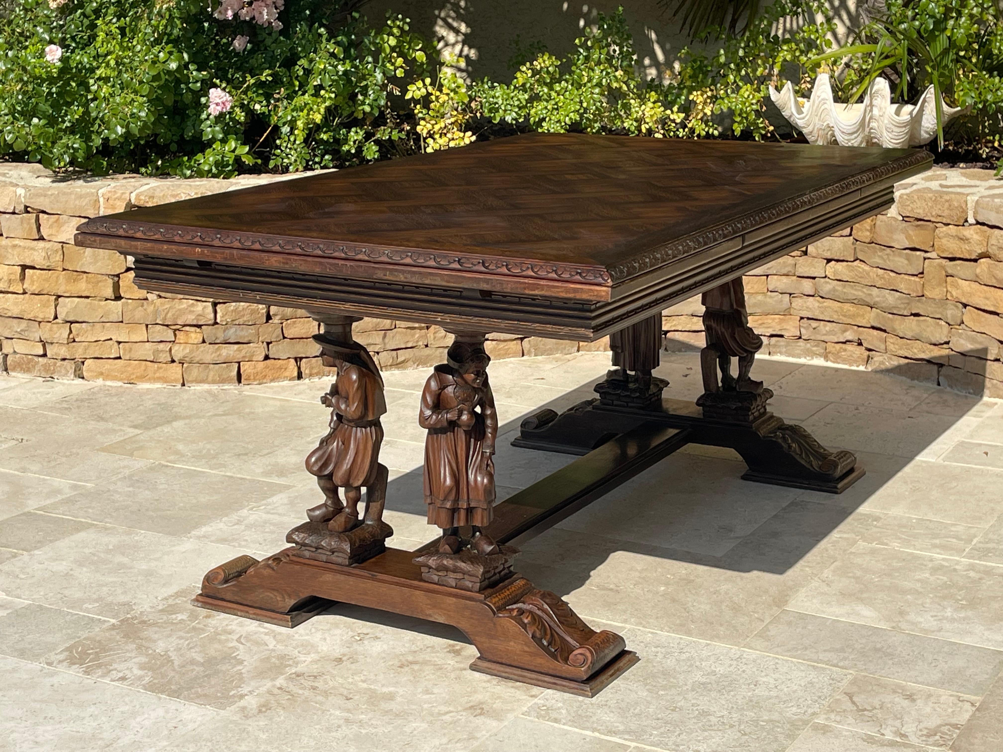 Beautiful Breton set consisting of a table and 6 chairs in carved oak. The base of the table is carved with full figures. The top is inlaid and, below, 2 extensions, open on either side. Each chair back is carved with a different scene. The set is