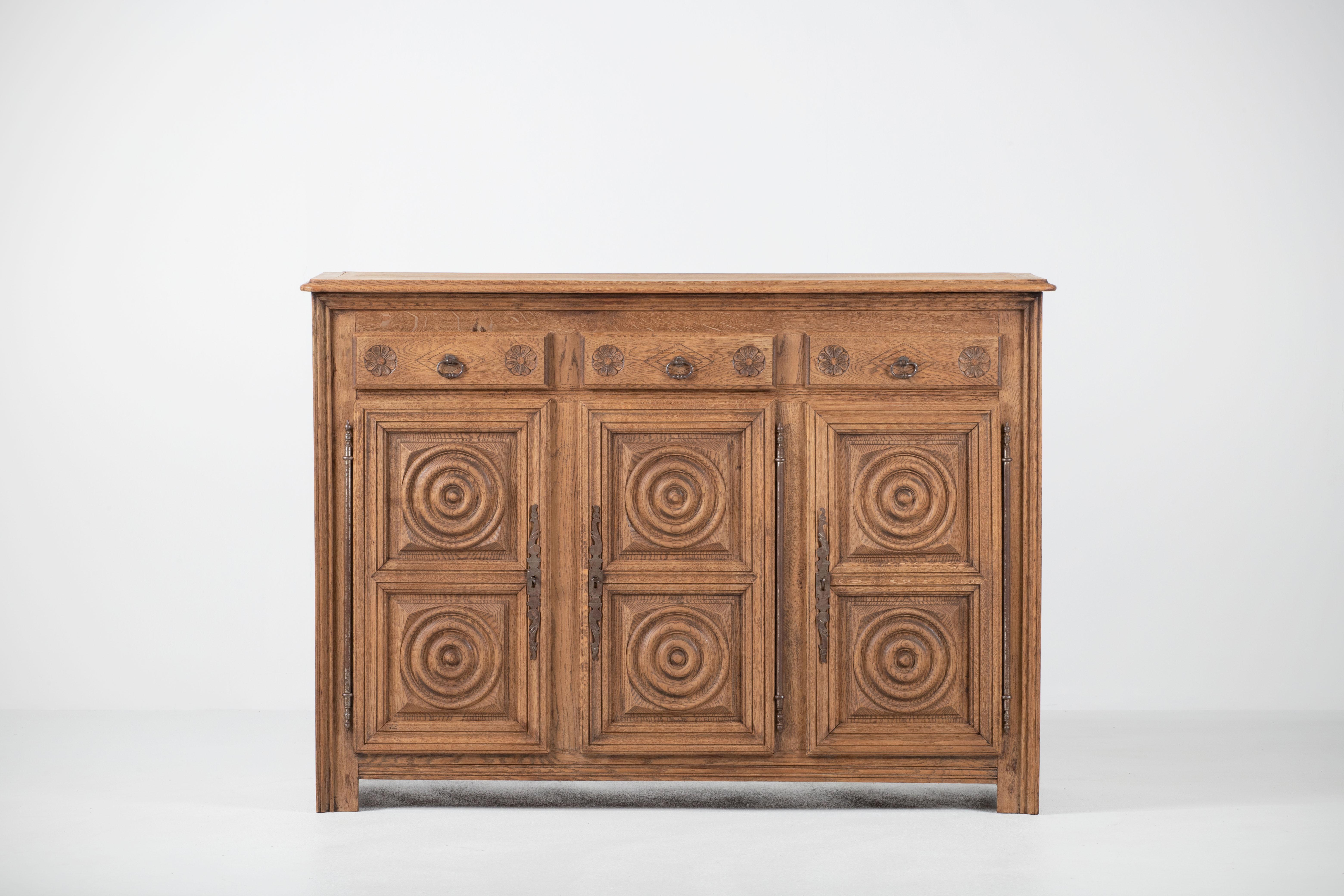 Unearthed in Normandy, this Breton style piece of furniture in solid oak will bring a touch of authenticity to an interior.
The sideboard consists of three compartments with shelves whose doors are covered with circular patterns typical of the