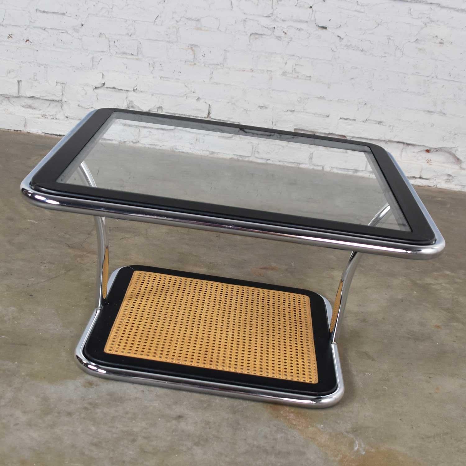Handsome Bauhaus style bent chrome tube, black painted wood, cane, and glass rounded square coffee table or end table in the style of Marcel Breuer but actually designed by Arthur Umanoff for Thonet. It is in wonderful vintage condition with no