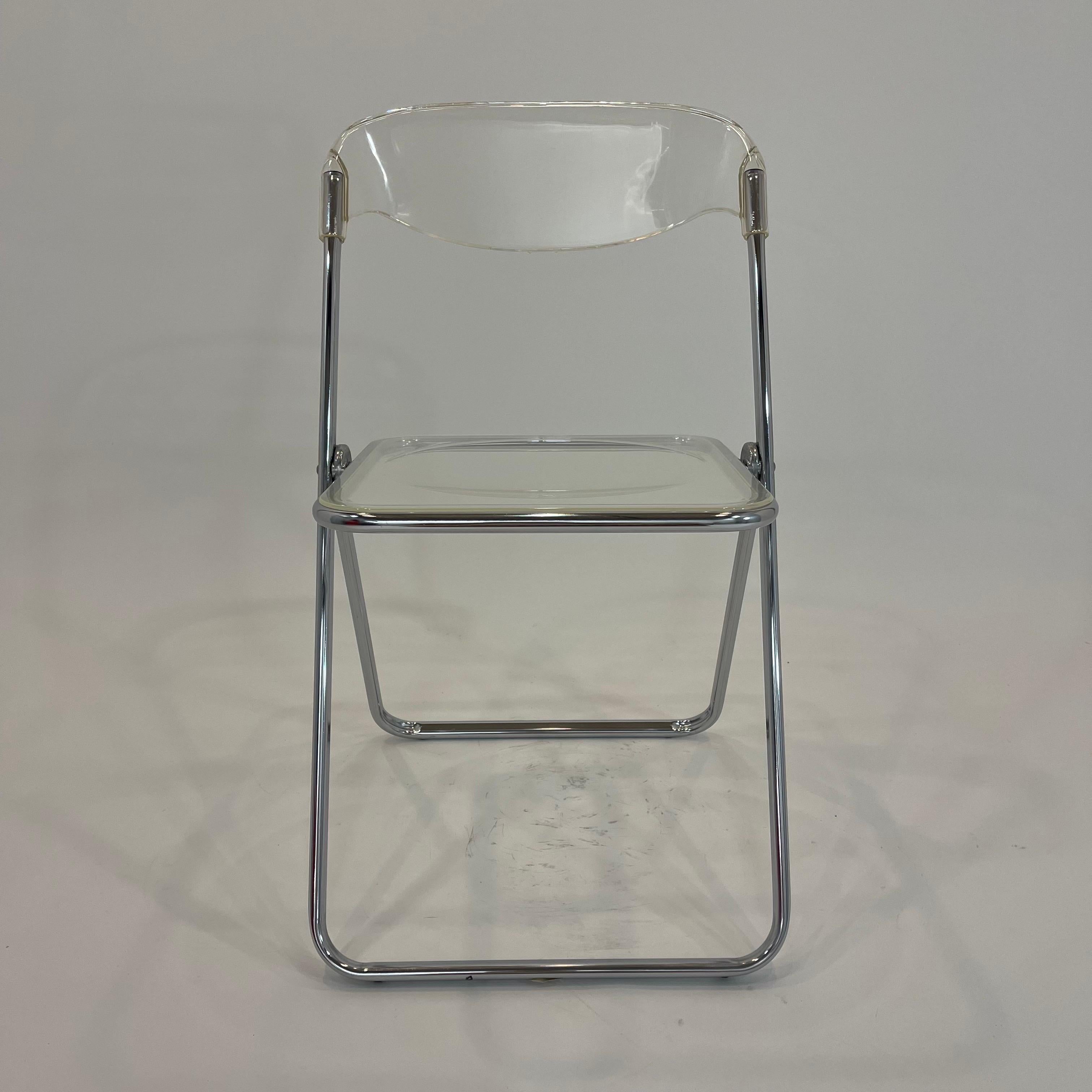 Versatile folding chair, perfect space saving midcentury design.  Rendered in a polished chrome and aluminum frame with molded acrylic lucite seat and back.  Stamped Brevettato on the frame and retaining its Made in Italy label on the bottom, 1970s.