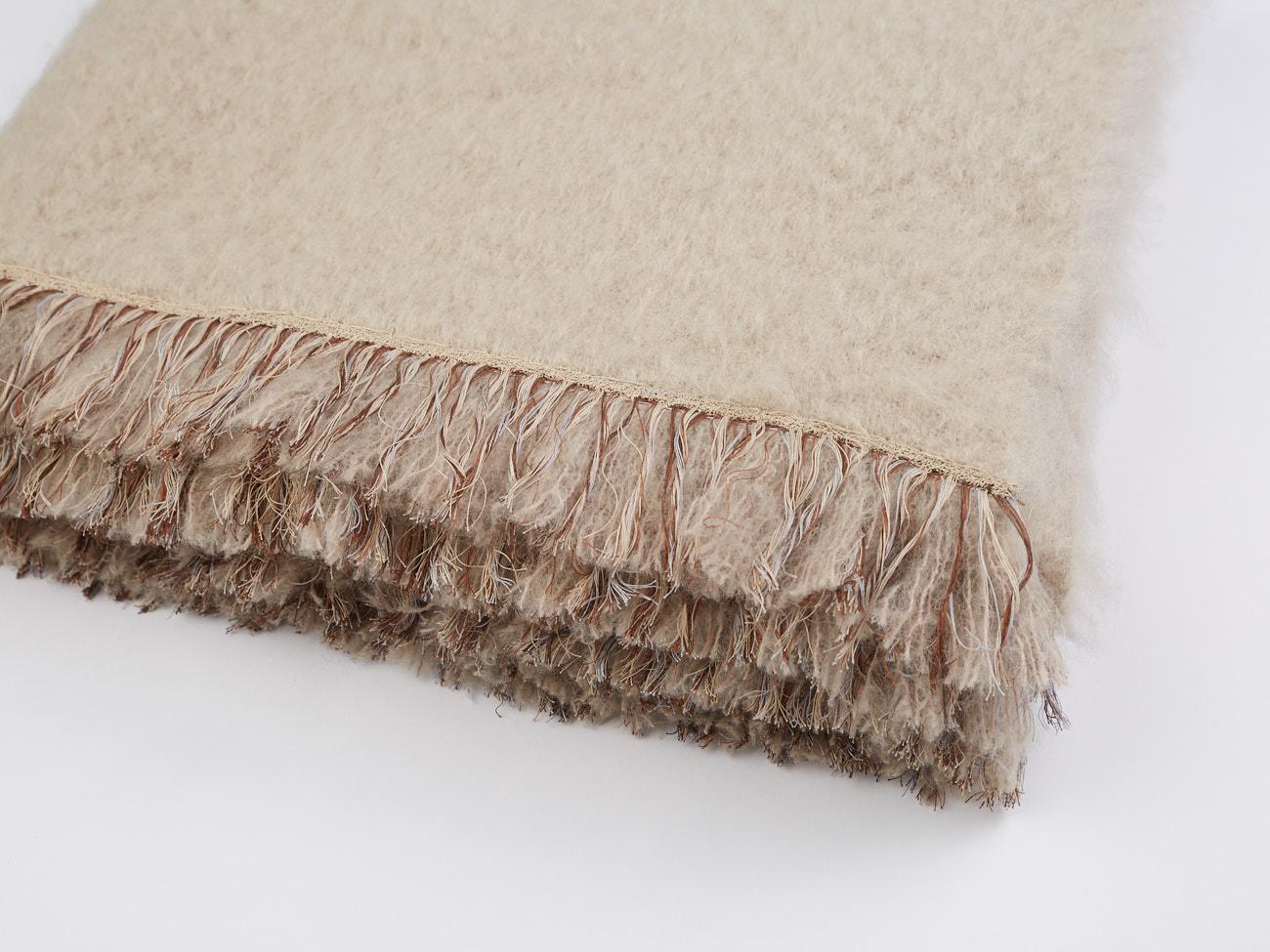 Brewster, a chique beige throw blanket made of the finest New Zealand mohair. Characterized with a hand embroidered fringe border completely embroidered by hand.
 
Based in the Netherlands and India's Uttar Pradesh, Jupe by Jackie is an