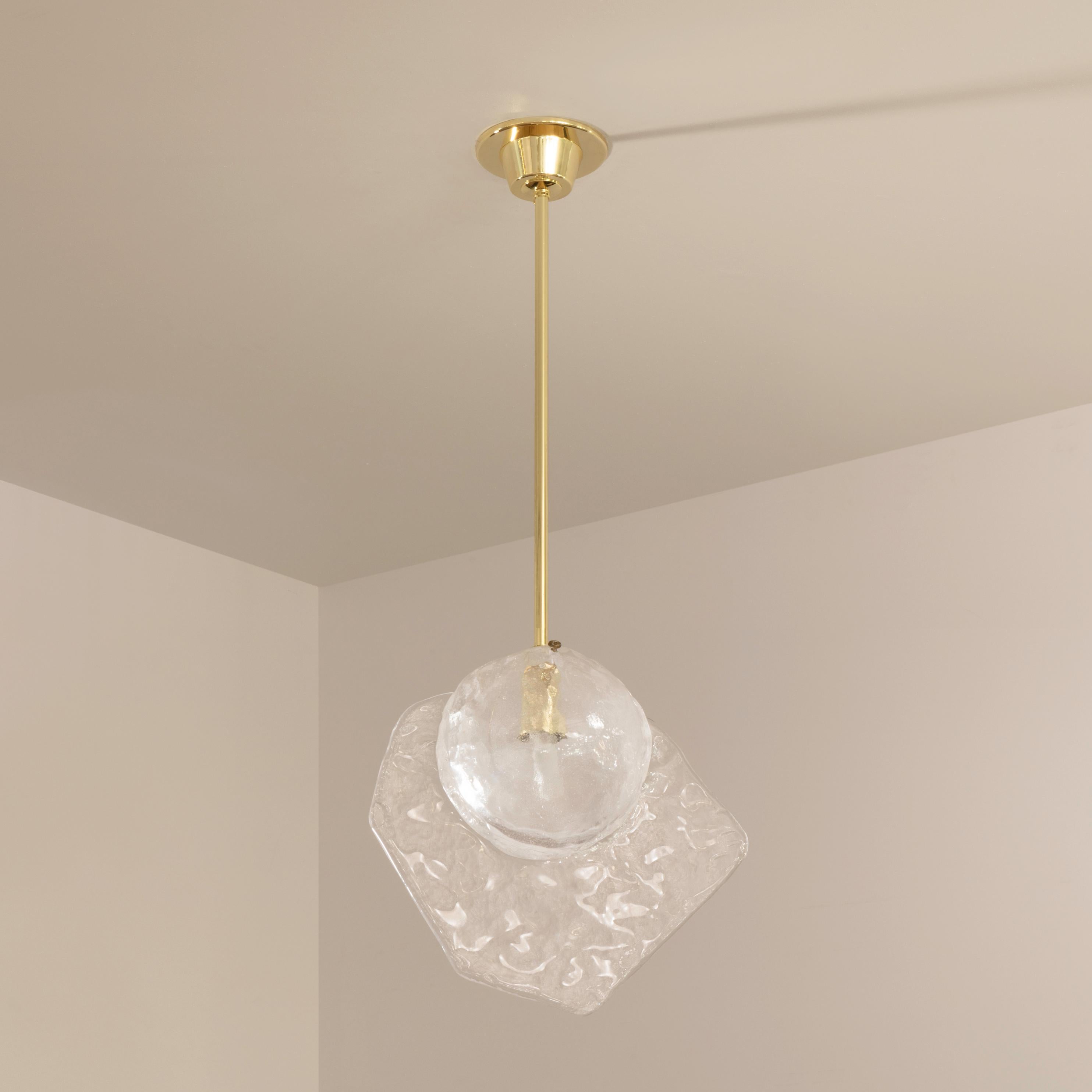 Inspired by the breeze of the venetian lagoon, the Brezza pendant, is constructed from hand blown Murano glass with a bubble infused core and a textured fin. Shown on a polished brass stem.

Customization Options:
Each fixture is hand crafted in