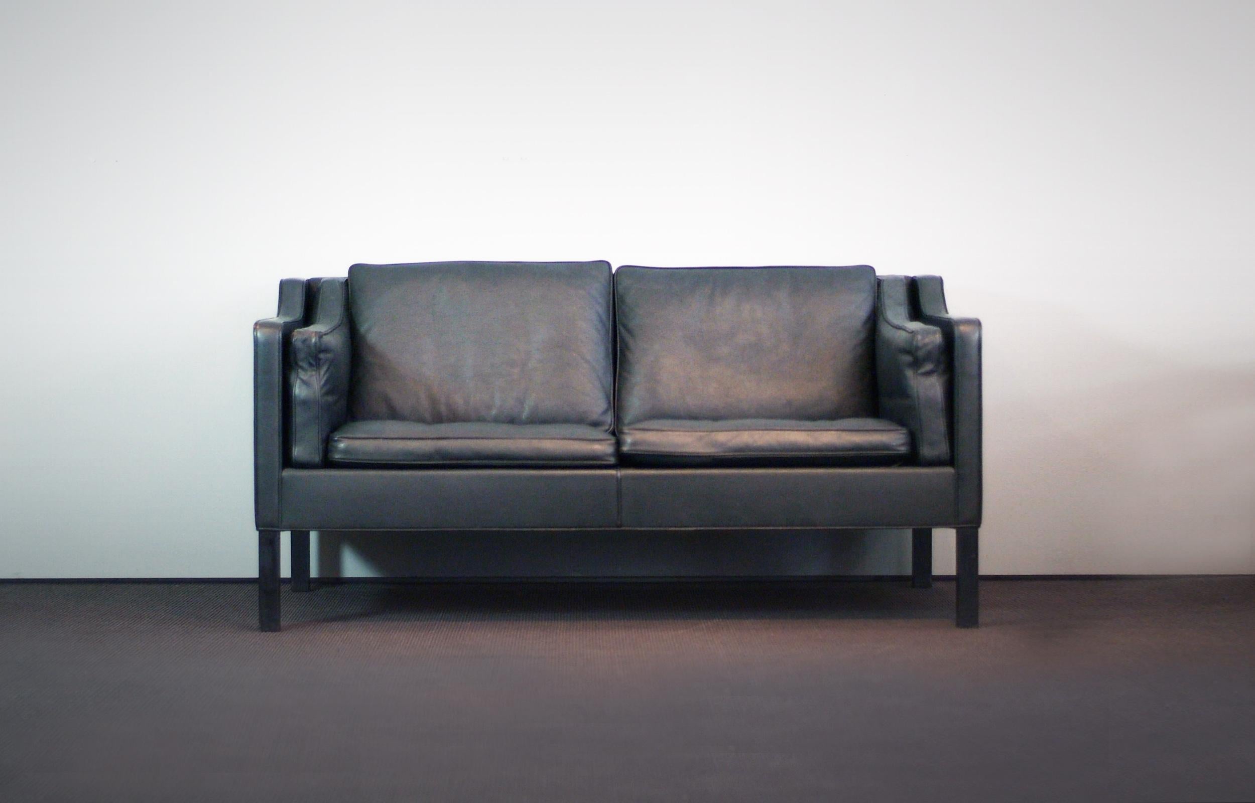 Wonderful two-seat sofa made by Fredericia and designed by Børge Mogensen in 1963. Original thick grained dark grey / black leather in perfect vintage condition (down filled cushions) and black stained feet. Signed with Paper Label.

Beautiful