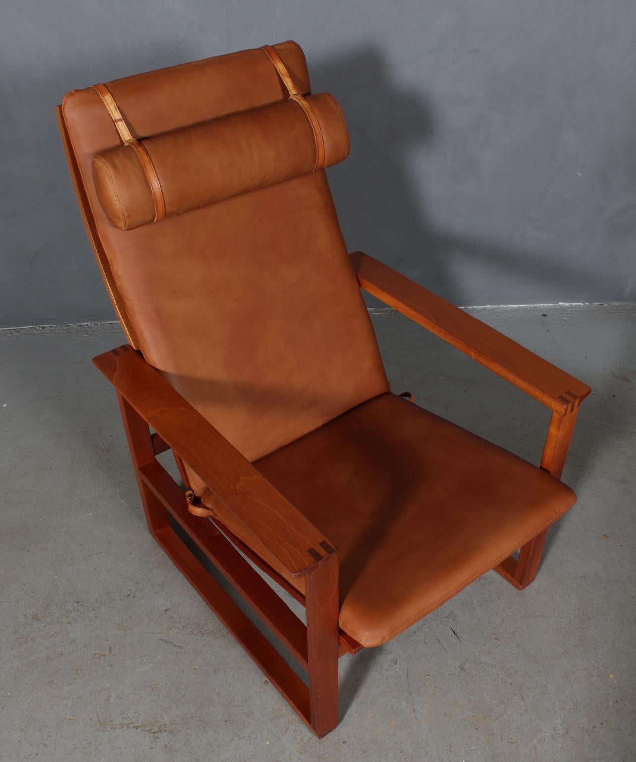 A Børge Mogensen lounge chairs designed in 1956 model number 2254 for Fredericia Stolefabrik. Cubical frames made of solid mahogany with finger joints and cane. 

Reupholstered in vintage tan aniline leather. The seat cushion can be fixed with a