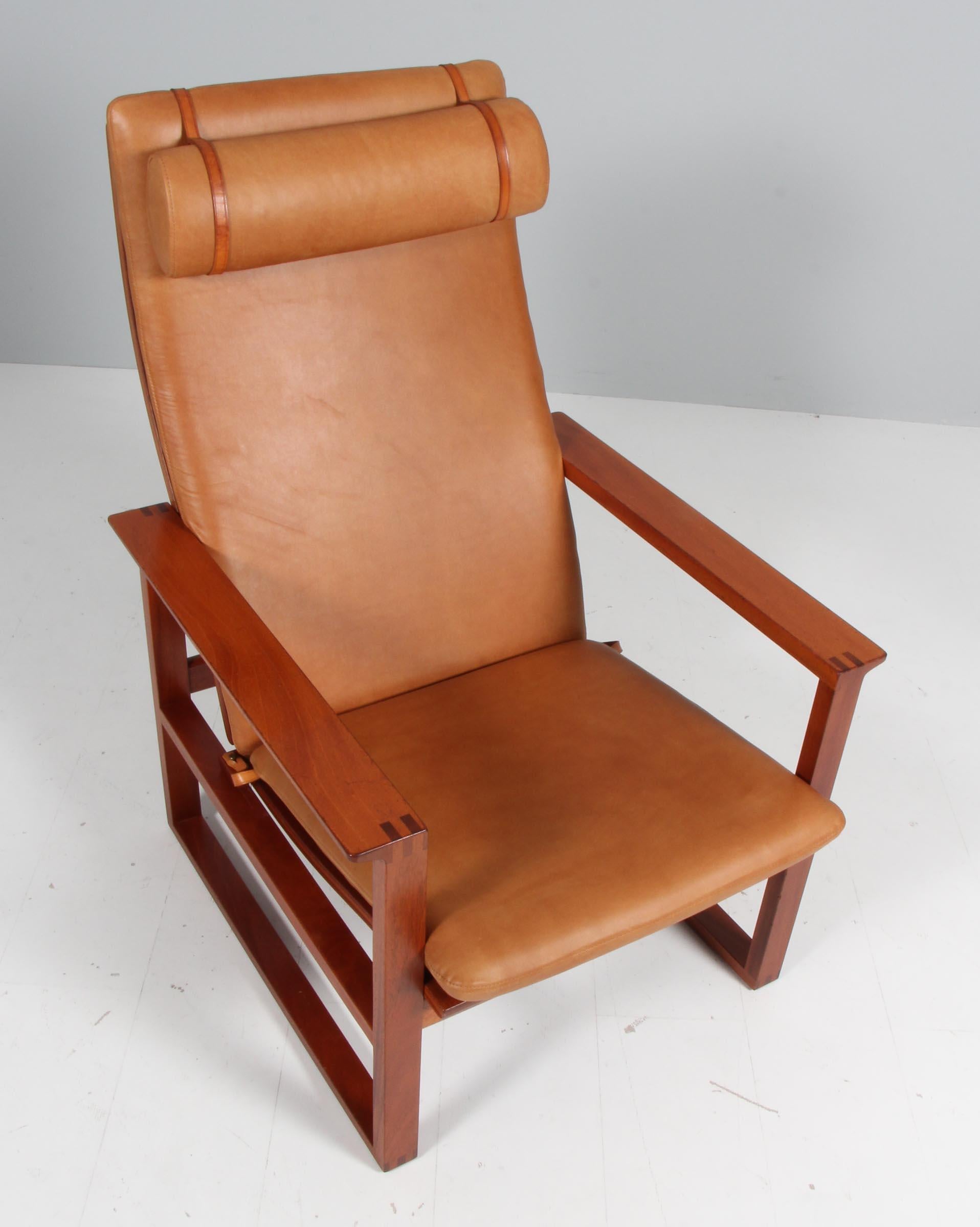 A Børge Mogensen lounge chairs designed in 1956 model number 2254 for Fredericia Stolefabrik. Cubical frames made of solid mahogany with finger joints and cane. 

Reupholstered in vintage tan aniline leather. The seat cushion can be fixed with a