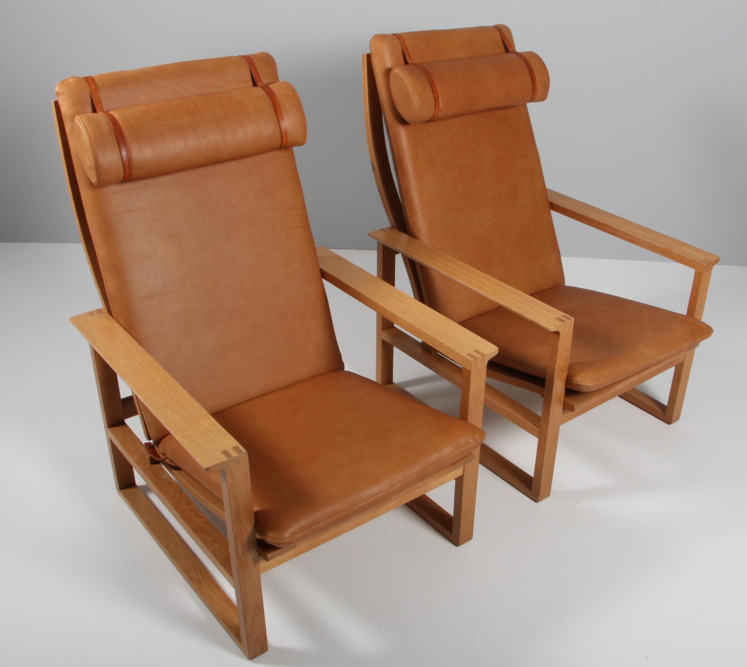 A Børge Mogensen lounge chairs designed in 1956 model number 2254 for Fredericia Stolefabrik. Cubical frames made of solid oak with finger joints.

New upholstered with vintage aniline leather. The seat cushion can be fixed with a leather strap