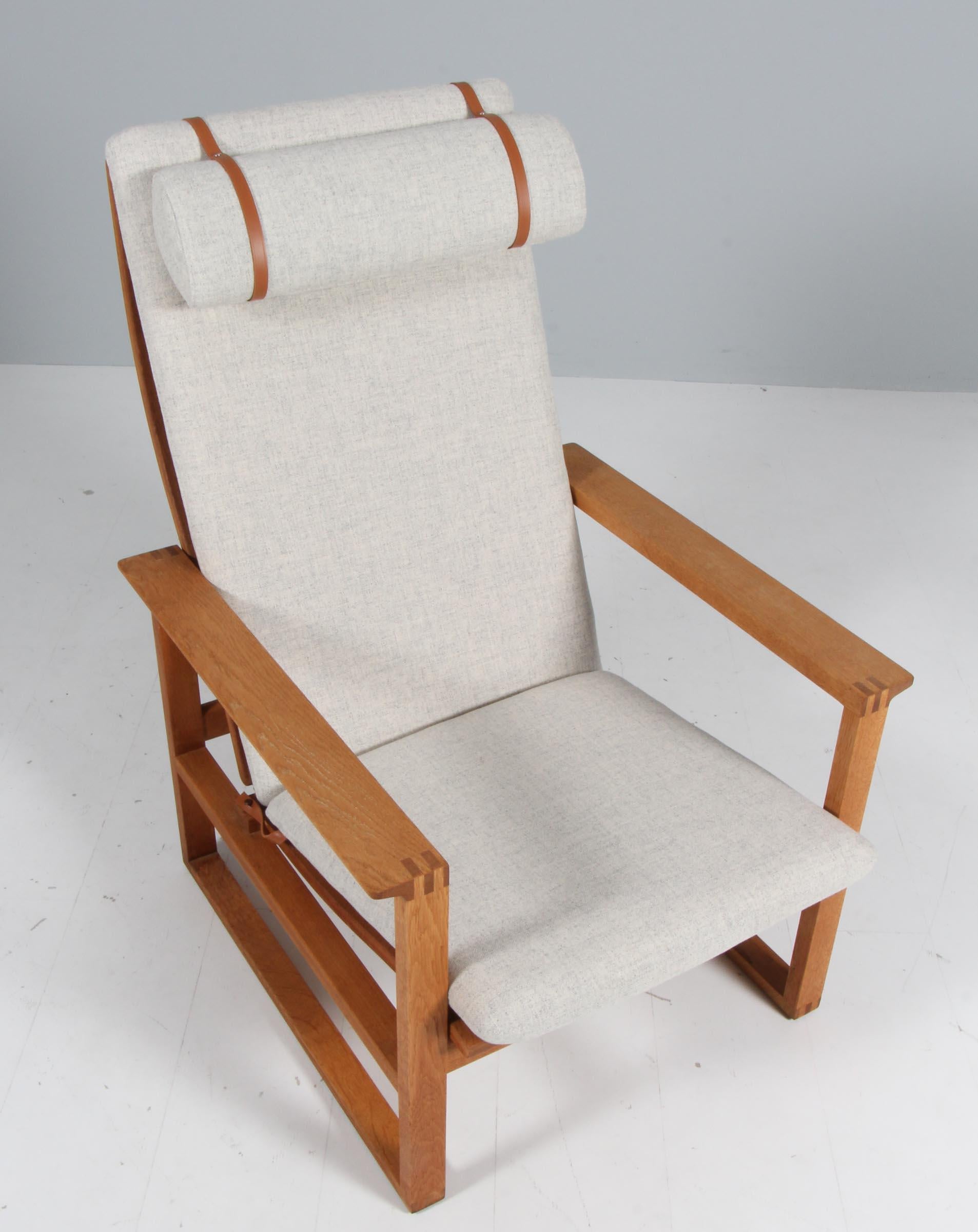A Børge Mogensen lounge chairs designed in 1956 model number 2254 for Fredericia Stolefabrik. Cubical frames made of solid oak with finger joints.

New upholstered with Tonus woll from Kvadrat. The seat cushion can be fixed with a leather strap