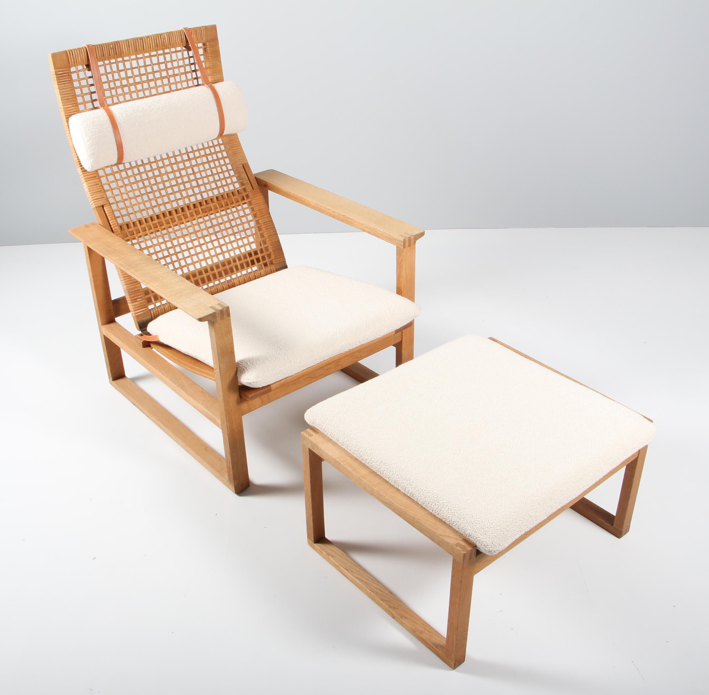 A Børge Mogensen lounge chair and ottoamn designed in 1956 model number 2254 for Fredericia Stolefabrik. Cubical frames made of solid oak with finger joints and cane. This high back model 2254 also reclines.

Reupholstered in Boucle wool, the